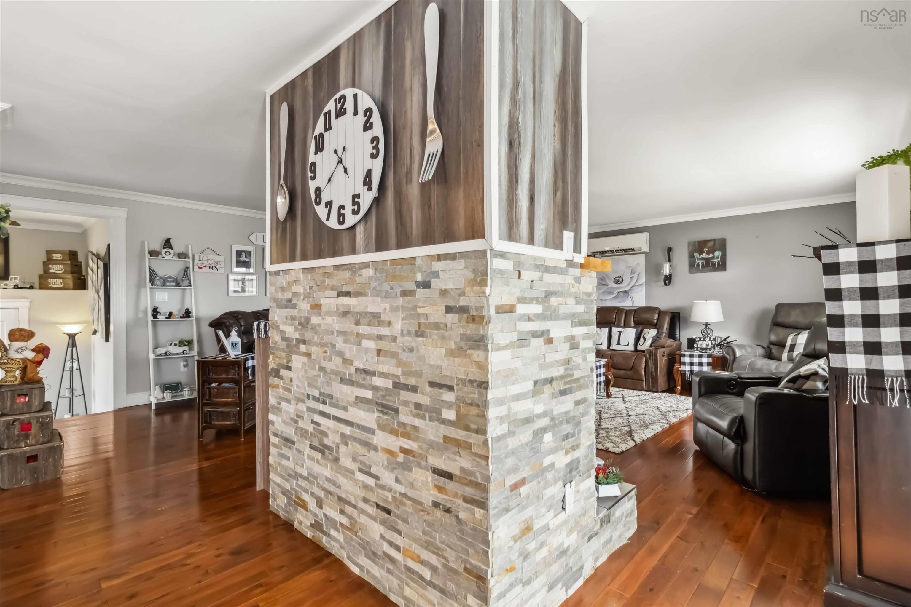 Hall featuring wood finished floors, ornamental molding, and a wall unit AC