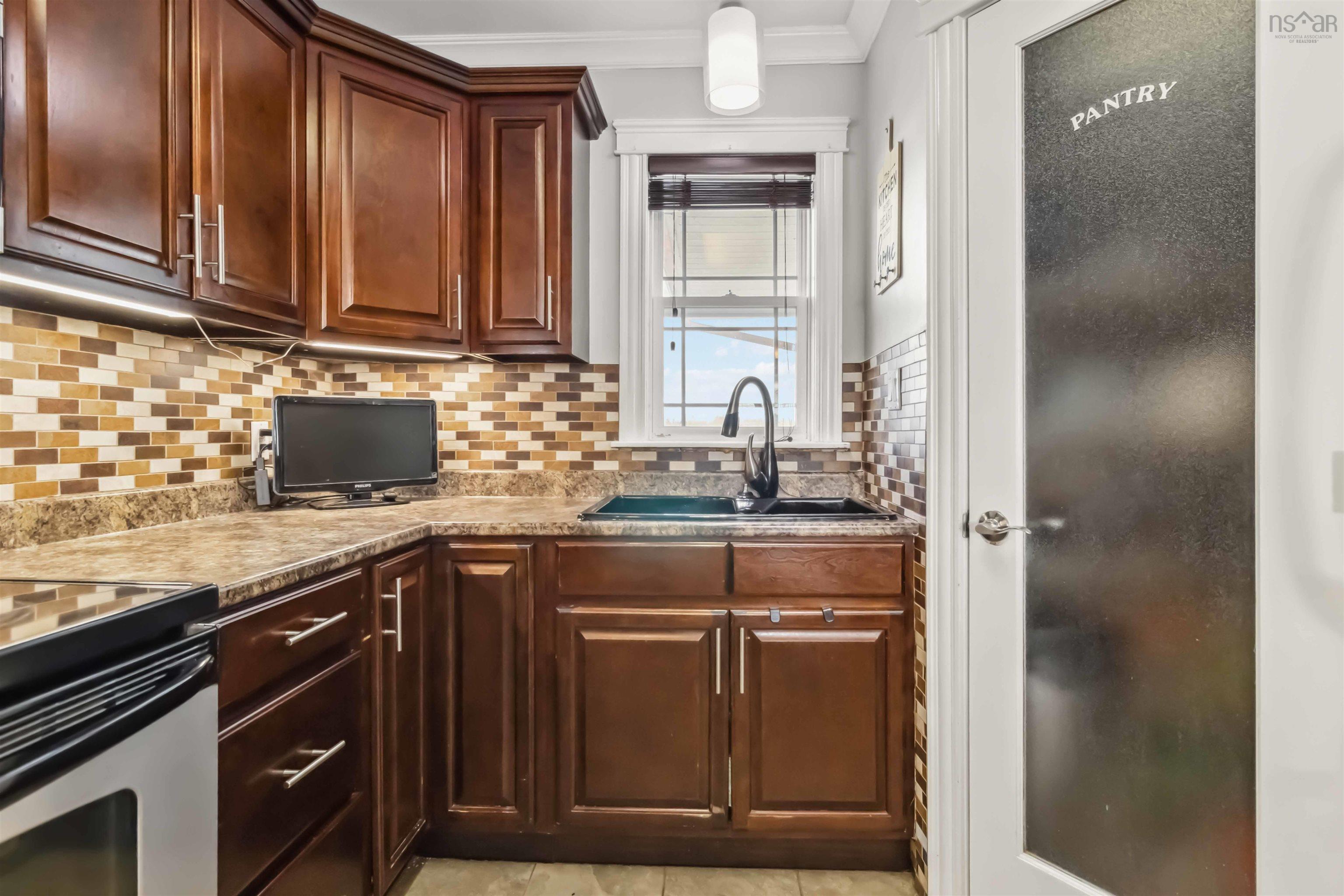 Kitchen with a sink, tasteful backsplash, stainless steel electric range, ornamental molding, and light countertops