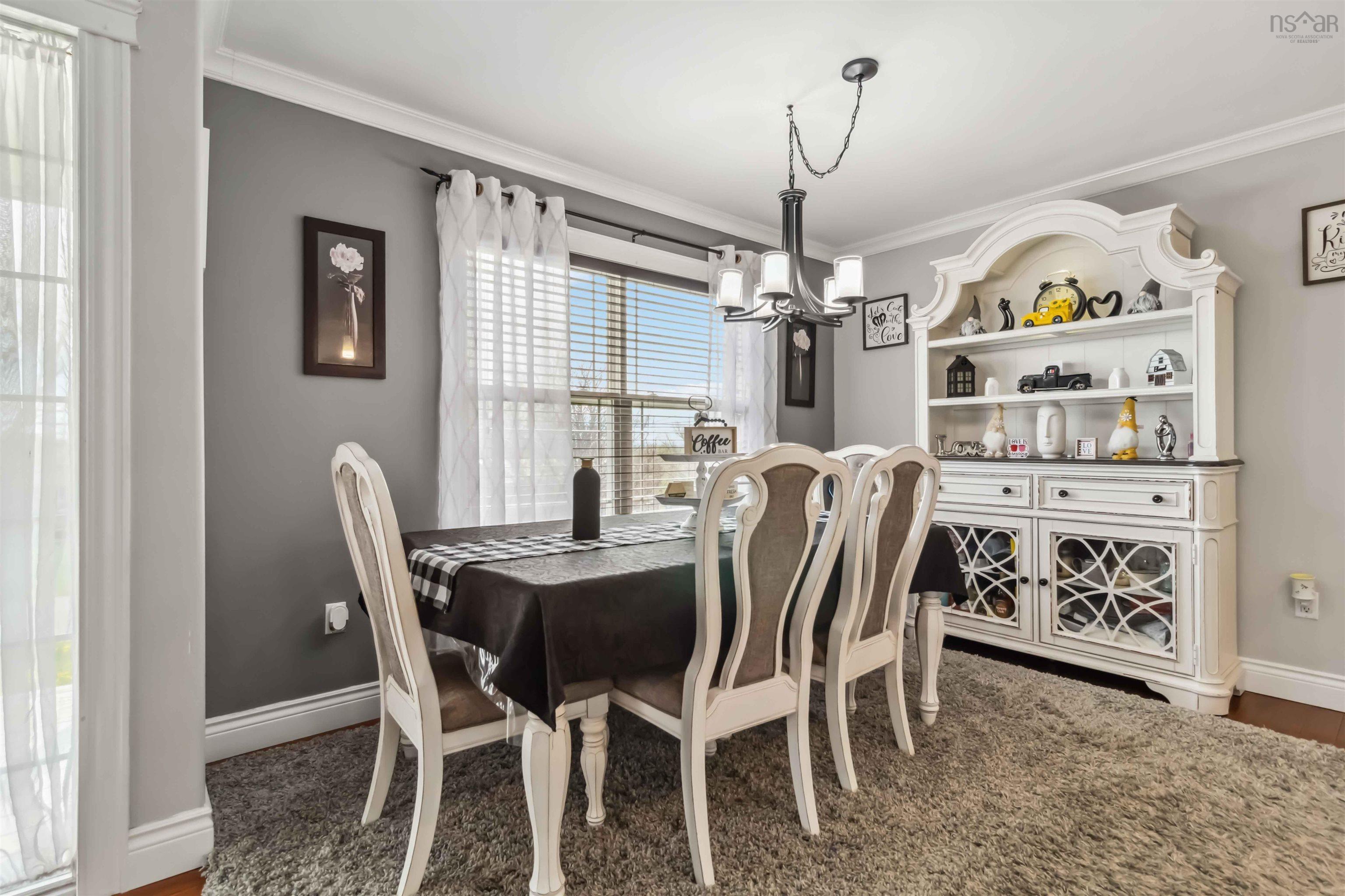 Dining area with ornamental molding, a chandelier, baseboards, and wood finished floors