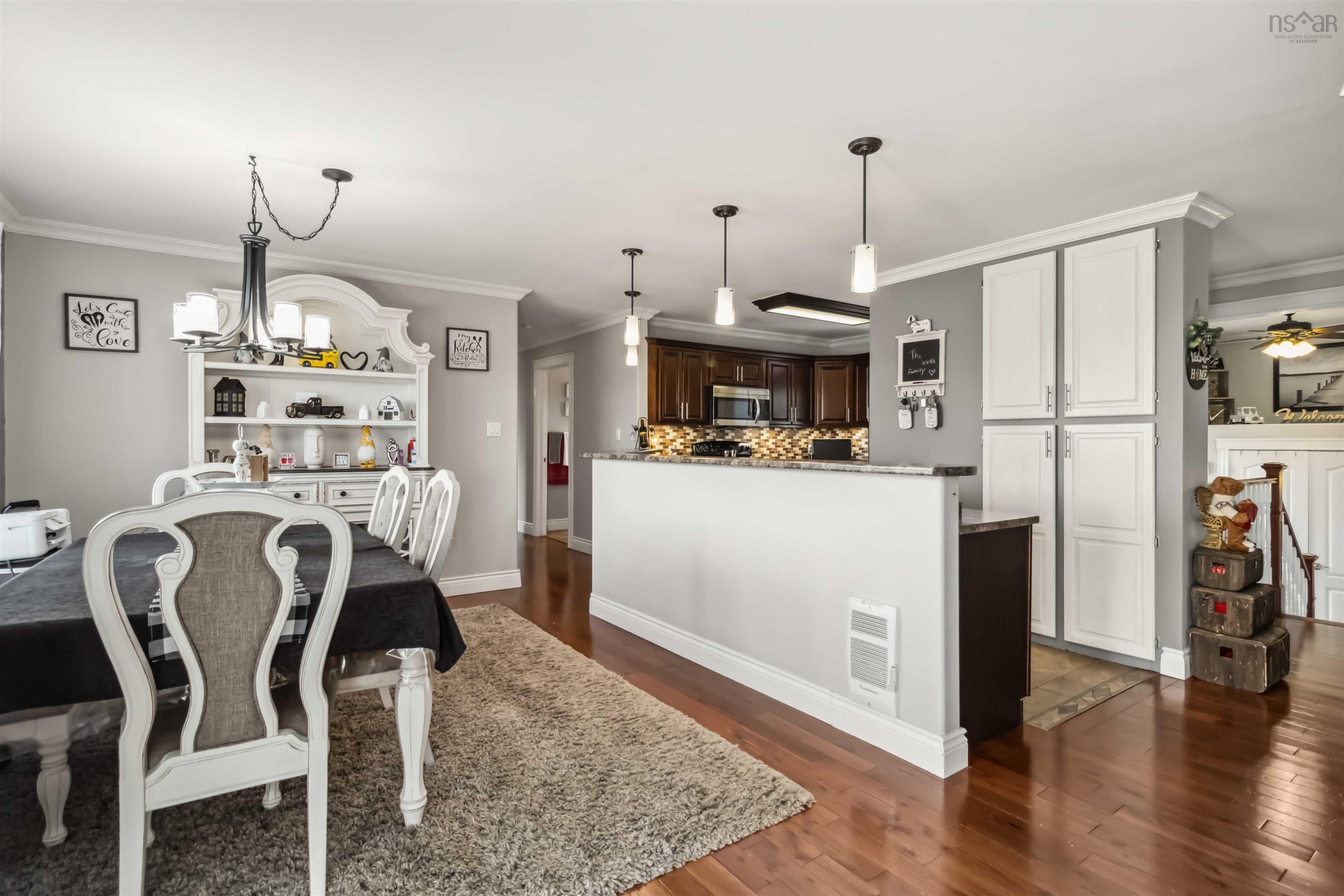 Dining space with crown molding, dark wood-style flooring, a chandelier, a ceiling fan, and baseboards