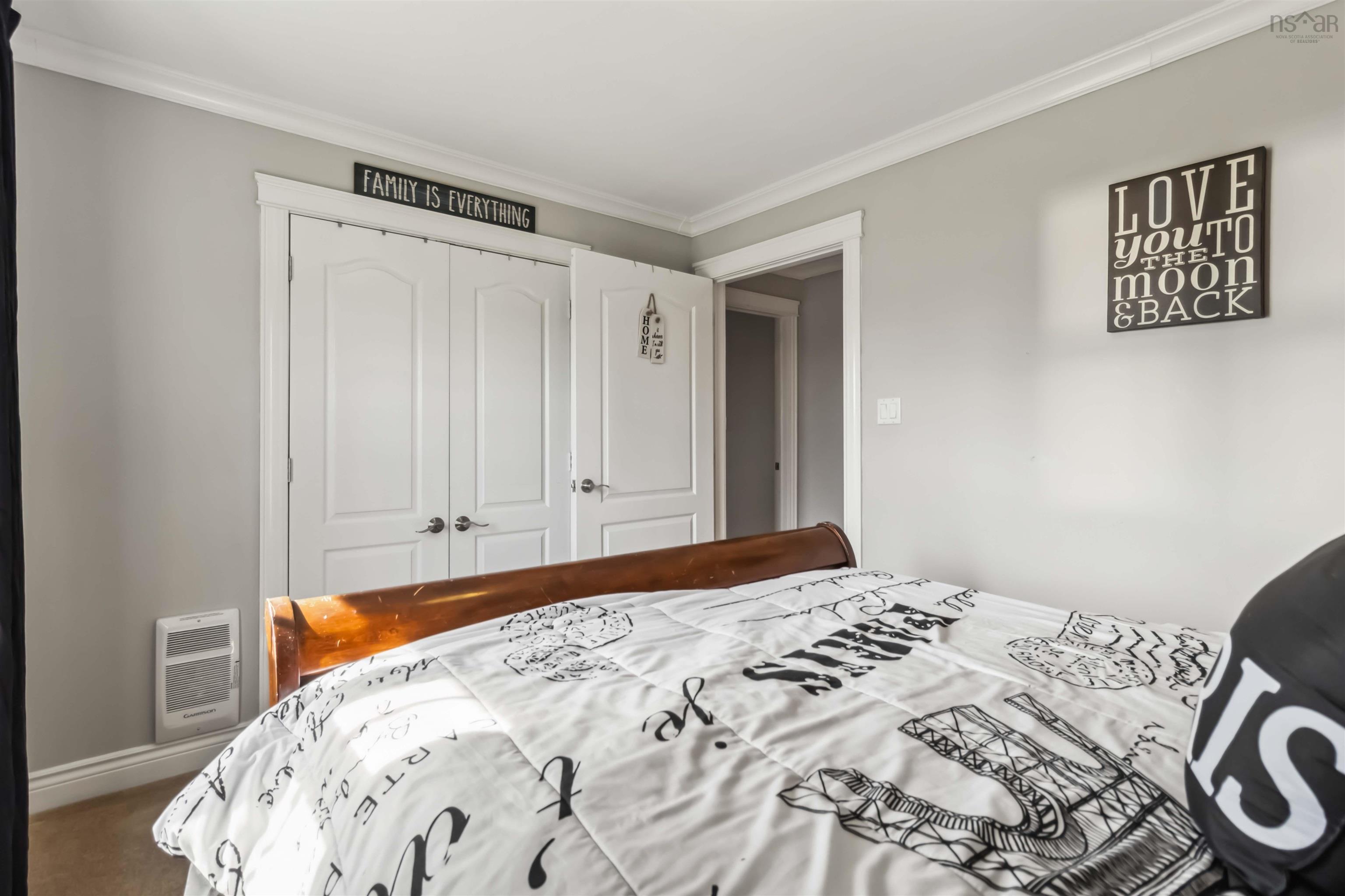 Bedroom featuring heating unit, a closet, crown molding, and baseboards