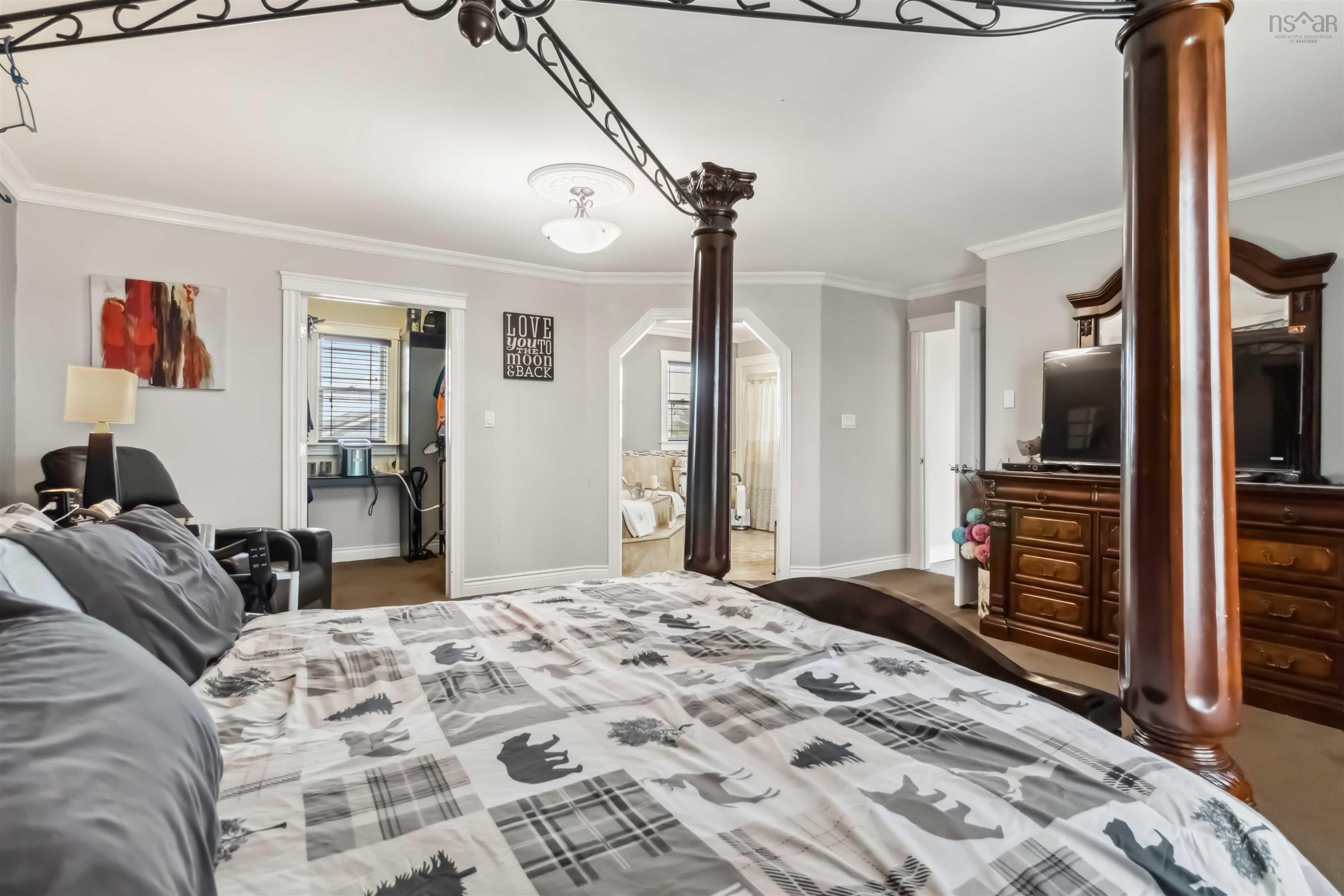 Bedroom featuring crown molding, arched walkways, and baseboards