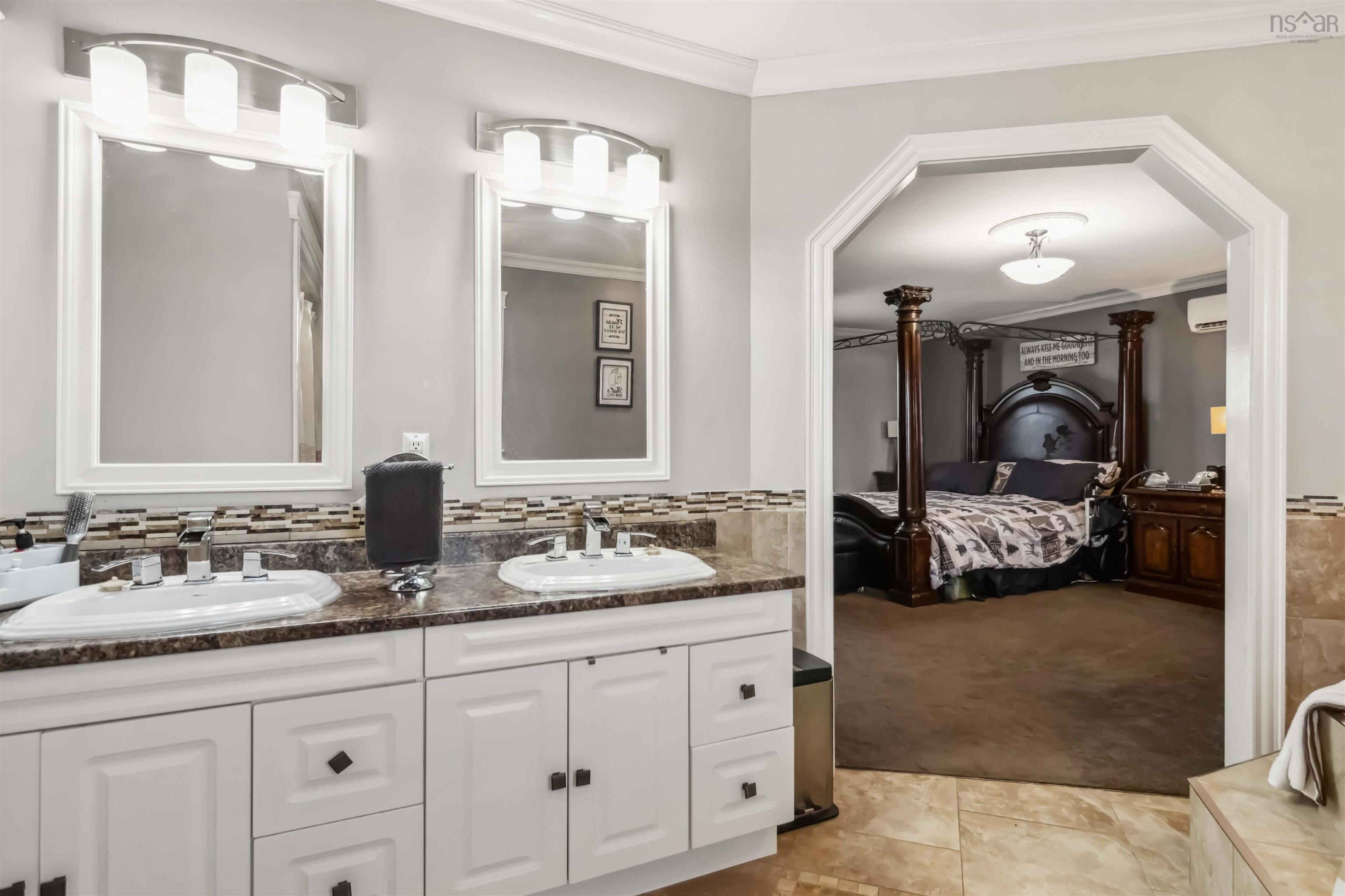 Full bathroom with crown molding, connected bathroom, double vanity, an AC wall unit, and tile patterned flooring