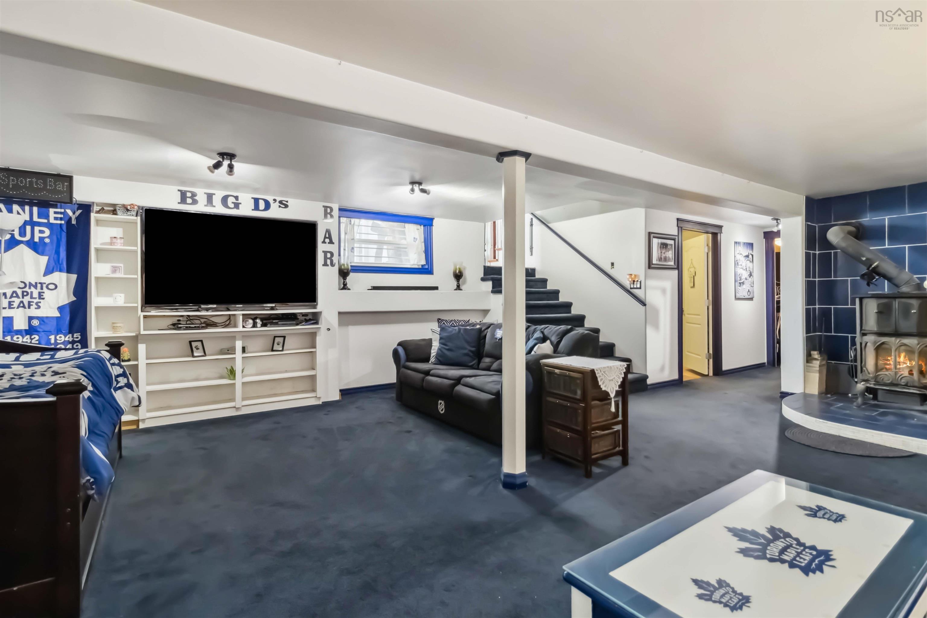 Living room with a wood stove, stairway, and carpet floors