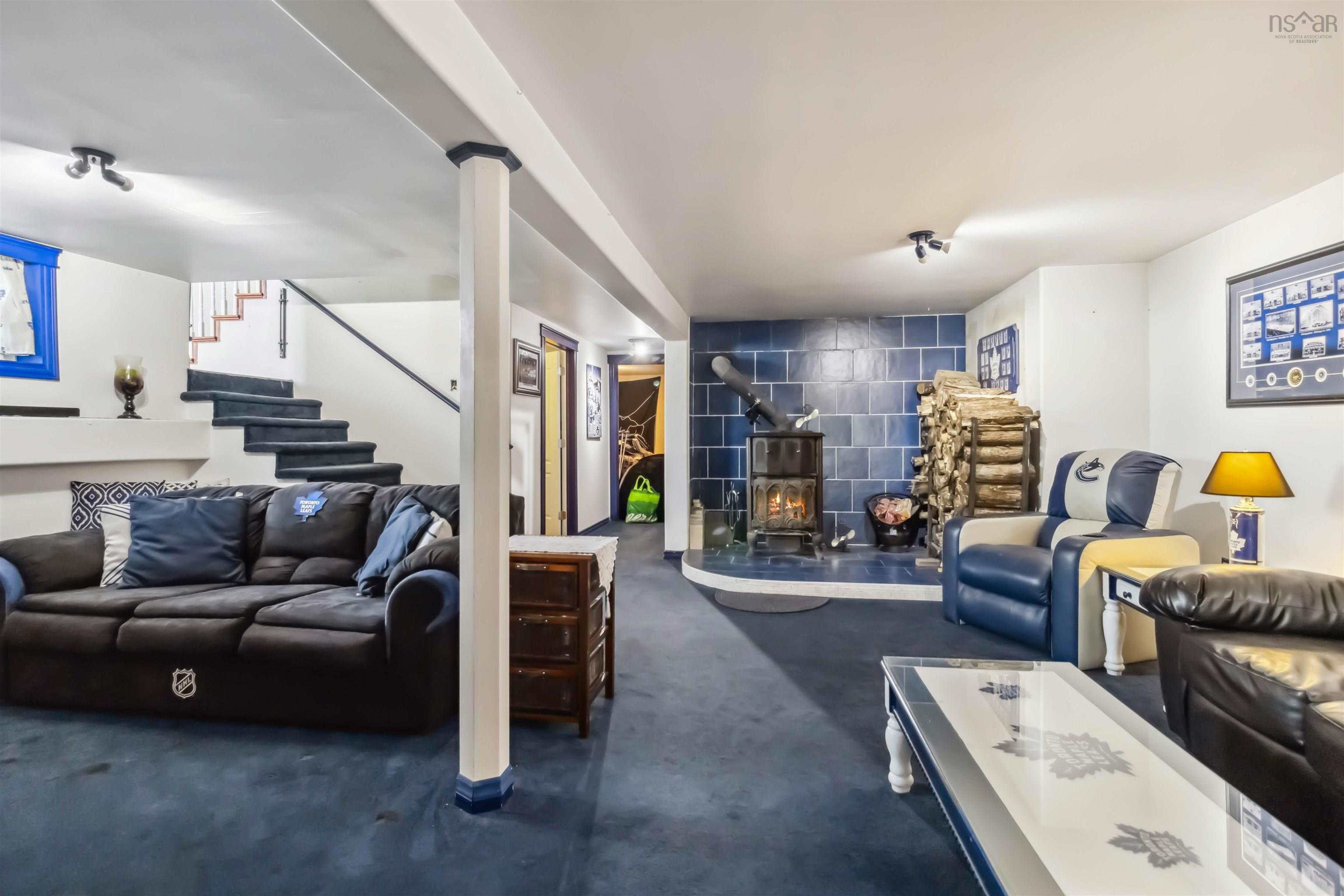 Living room with stairway and a wood stove
