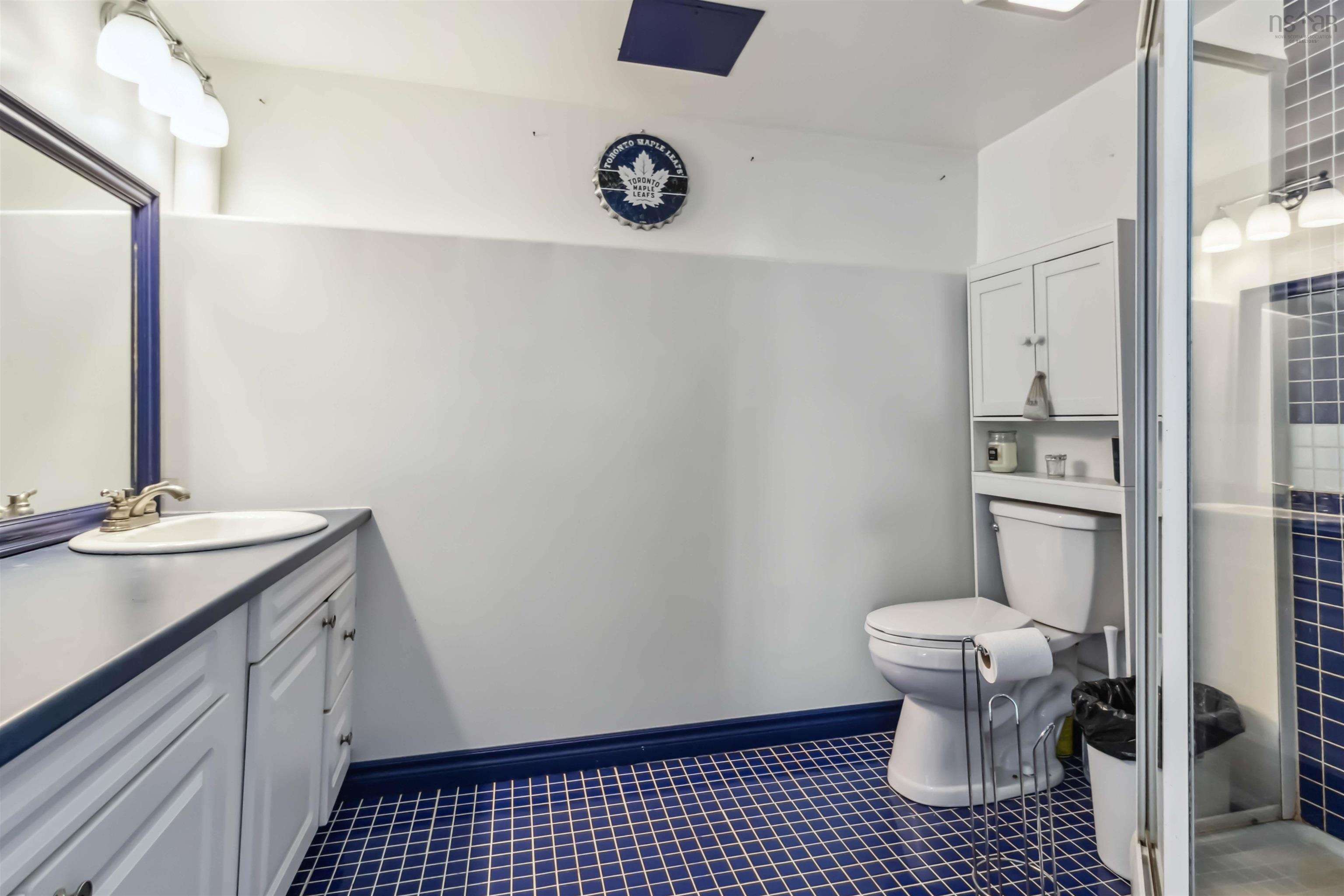 Bathroom featuring toilet, tile patterned flooring, vanity, and a shower stall
