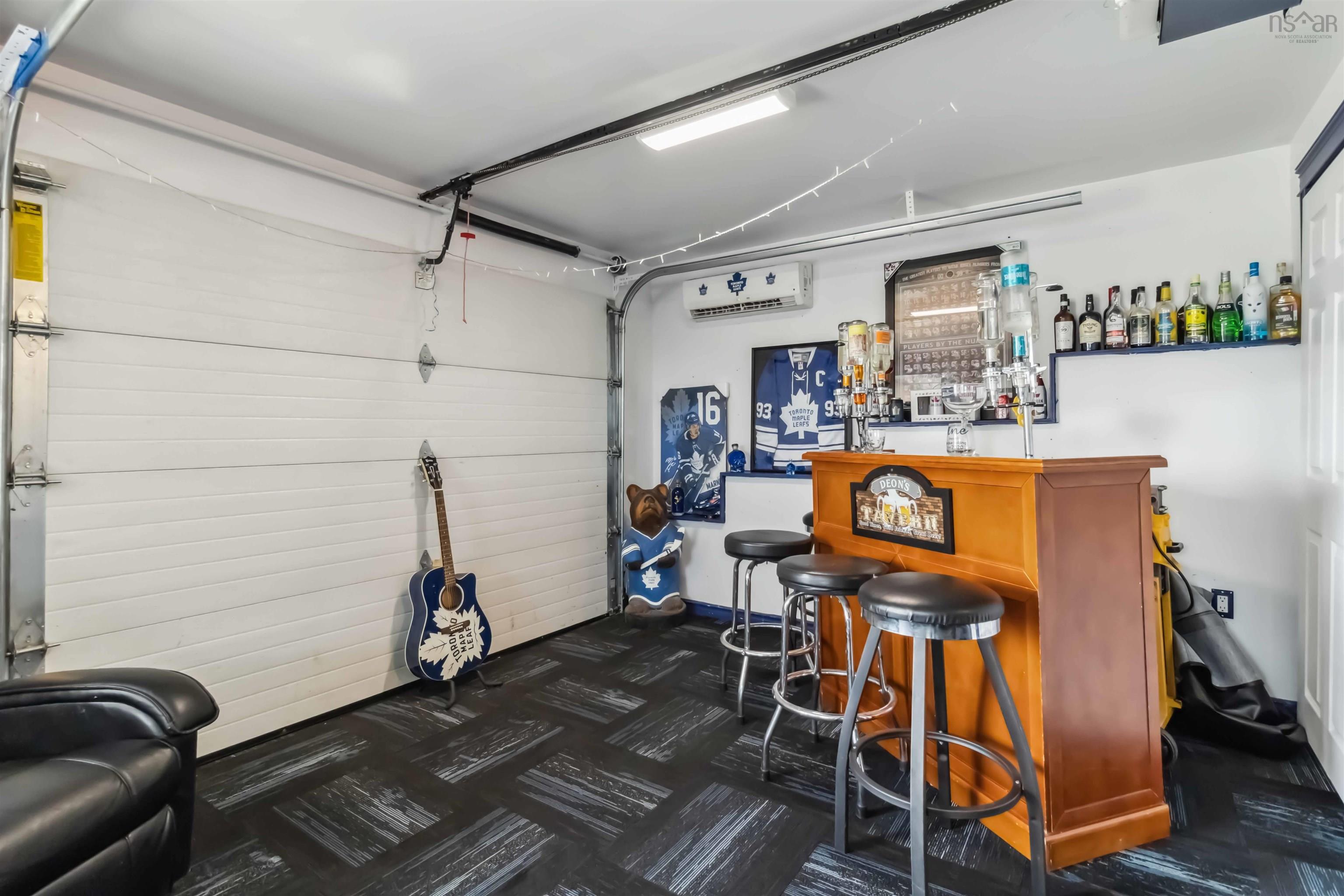 Indoor dry bar featuring an AC wall unit, dark carpet, and baseboards