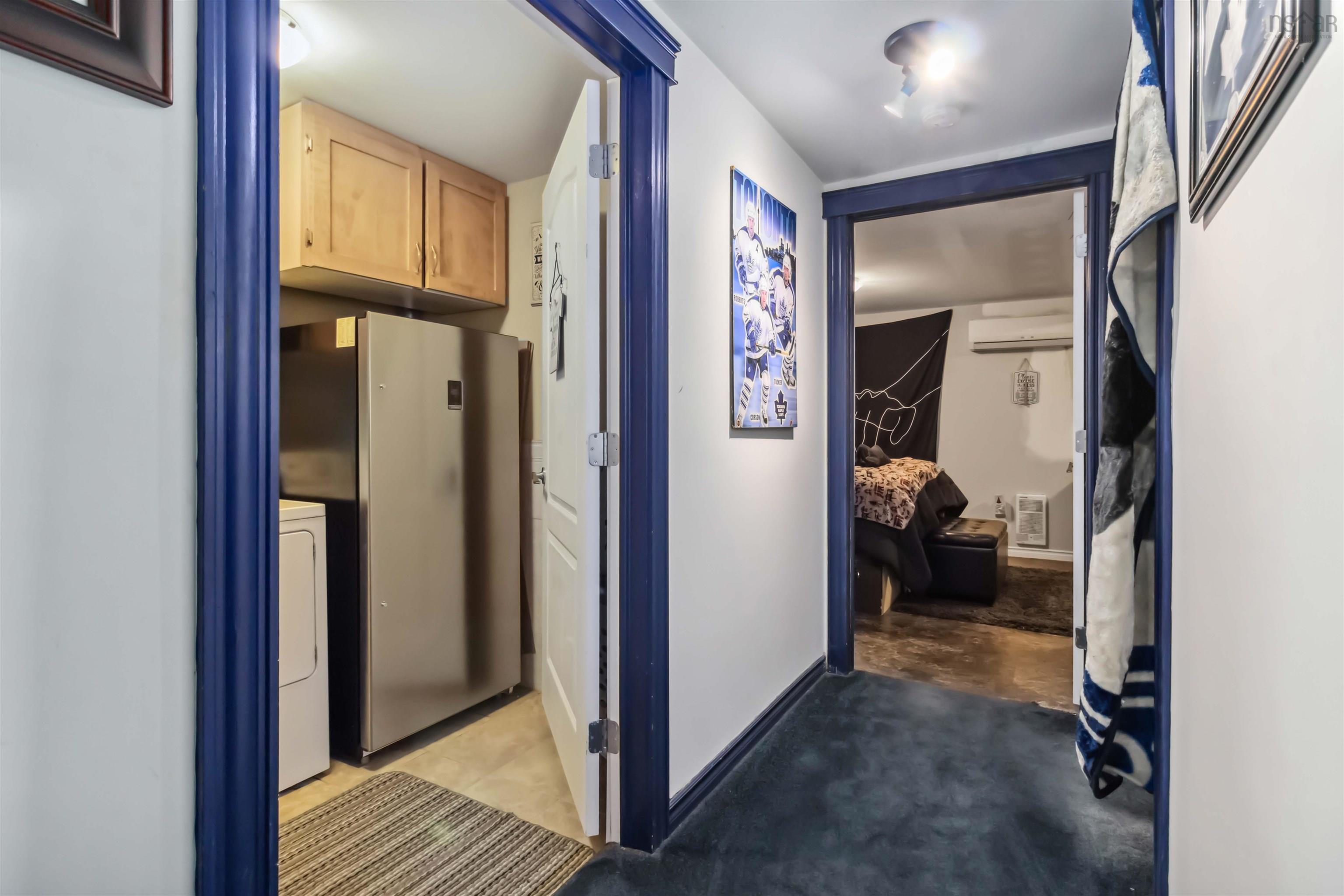 Hall with washer / dryer, baseboards, and a wall mounted AC