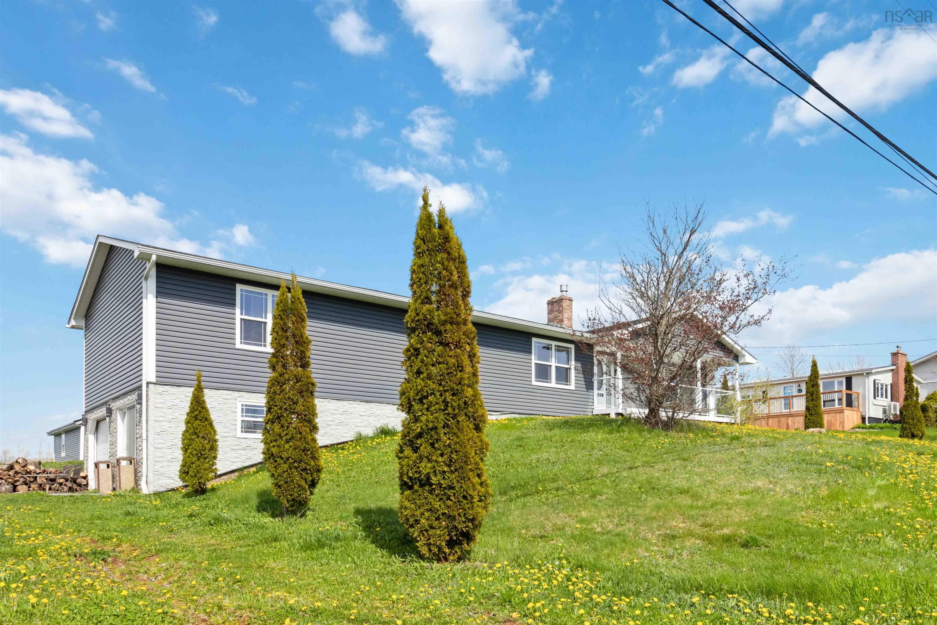 Back of house featuring a chimney, a garage, and a yard