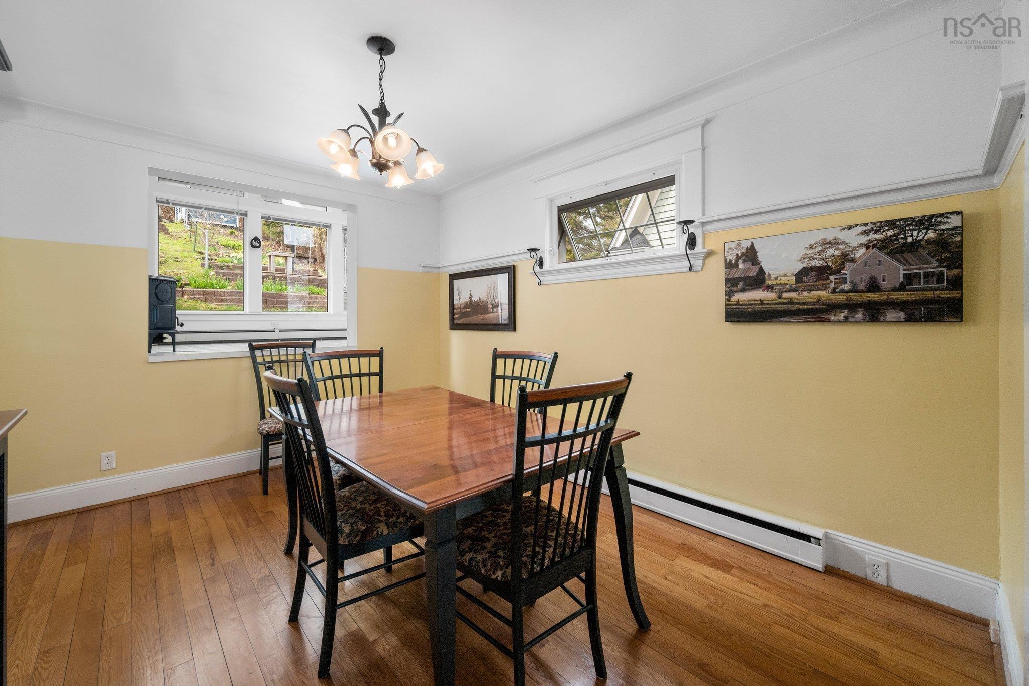 Dining room featuring a baseboard radiator, a chandelier, healthy amount of natural light, and wood-type flooring