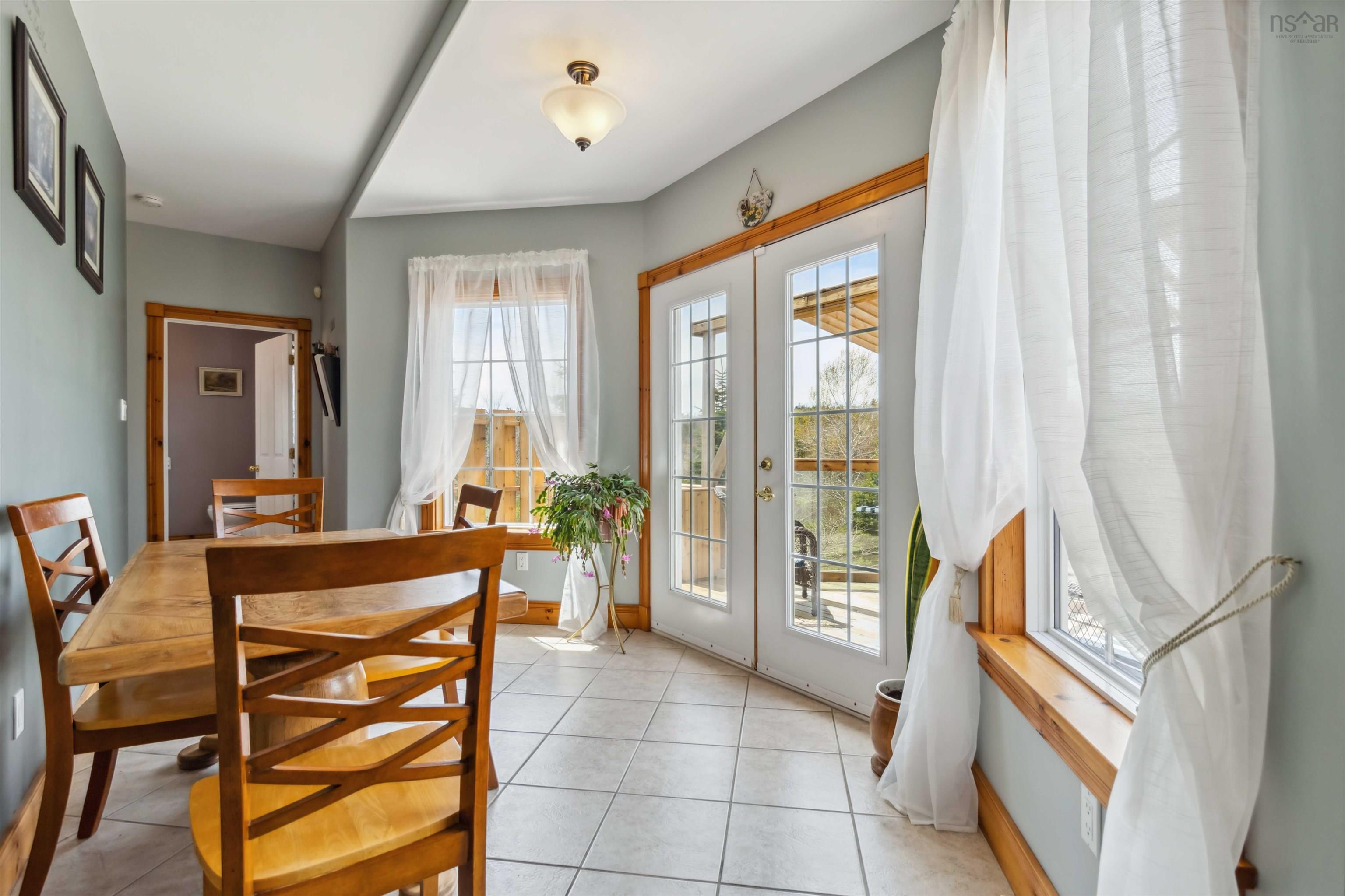 Dining space with french doors, light tile patterned flooring, and baseboards