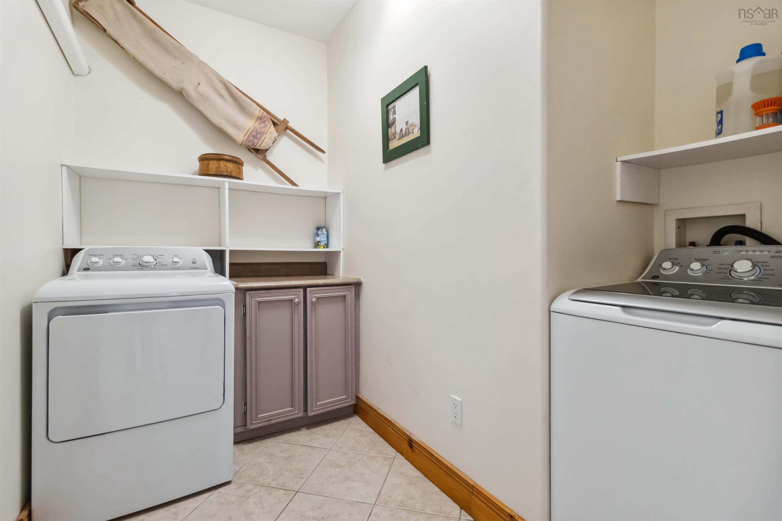 Laundry room with cabinet space, light tile patterned flooring, and separate washer and dryer