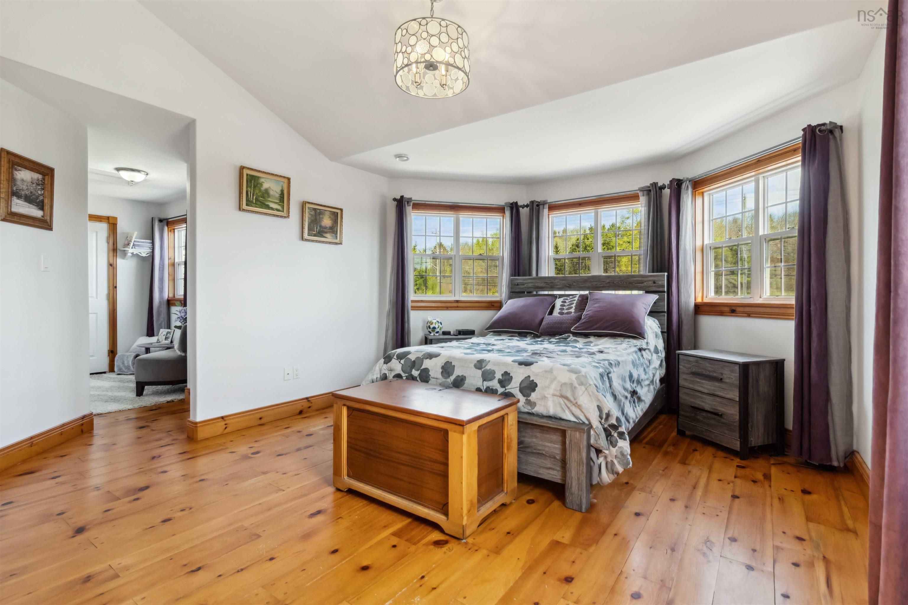 Bedroom with light wood-style flooring, vaulted ceiling, baseboards, and a chandelier