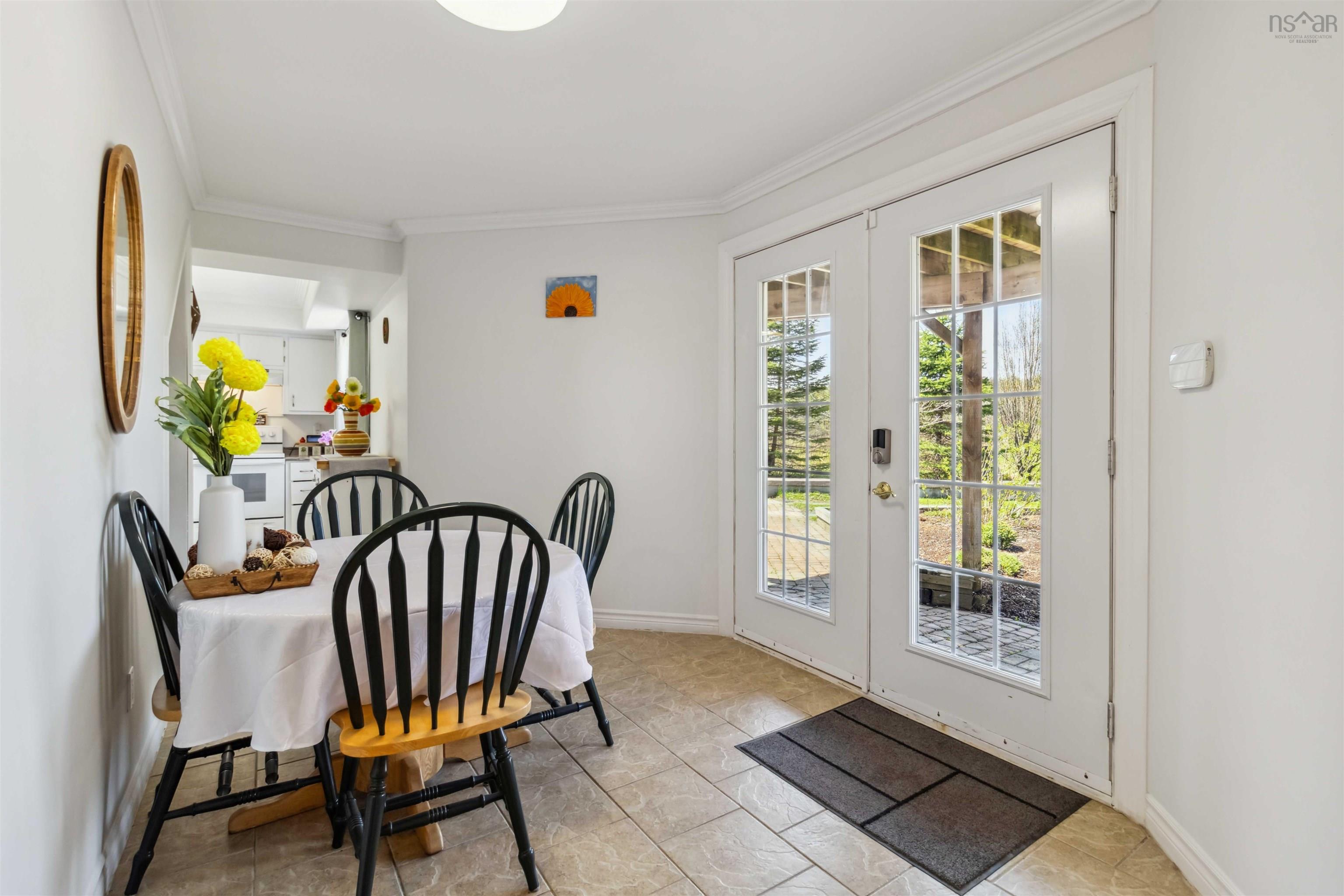 Dining space with french doors, ornamental molding, and baseboards