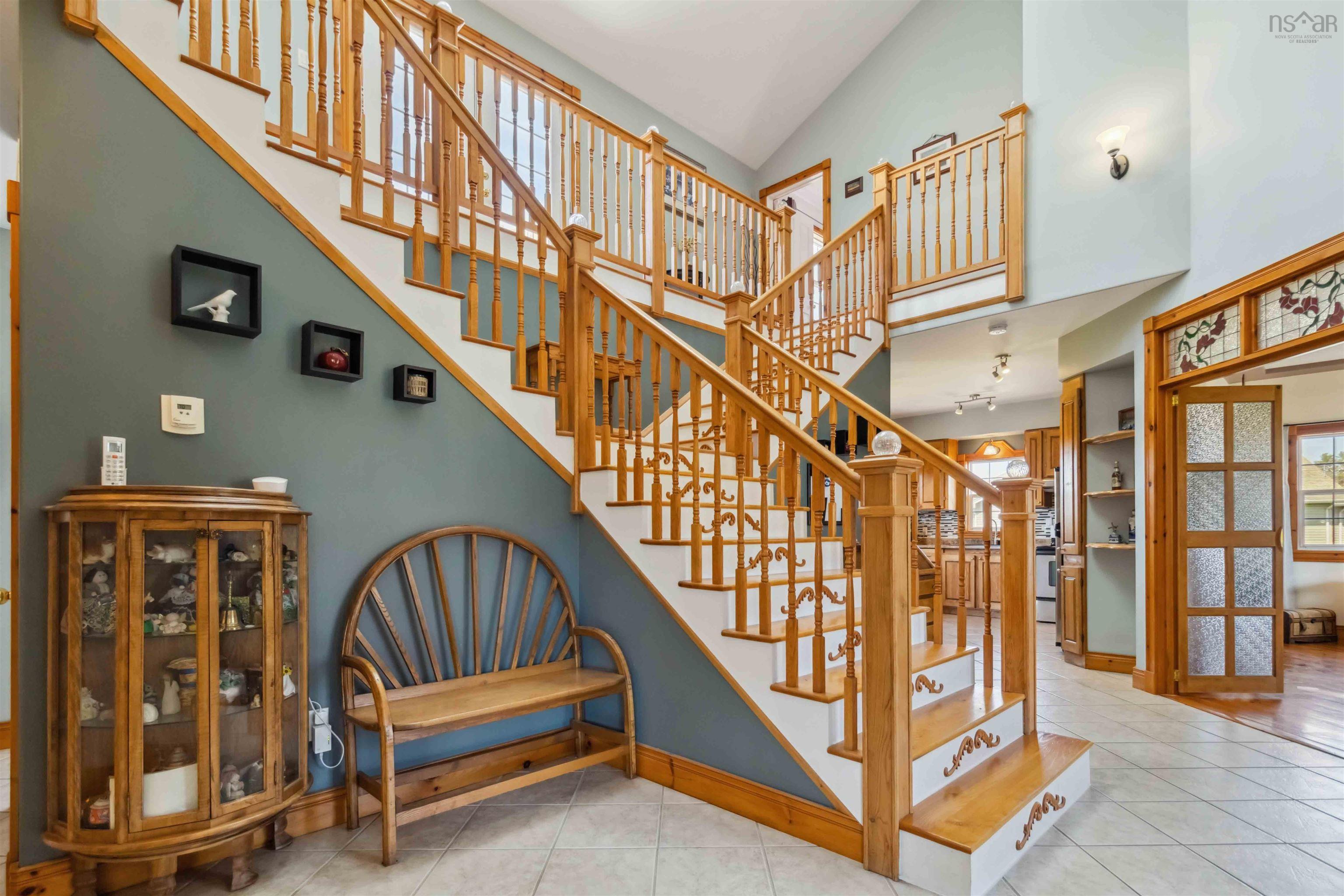 Stairs featuring high vaulted ceiling, tile patterned floors, and baseboards