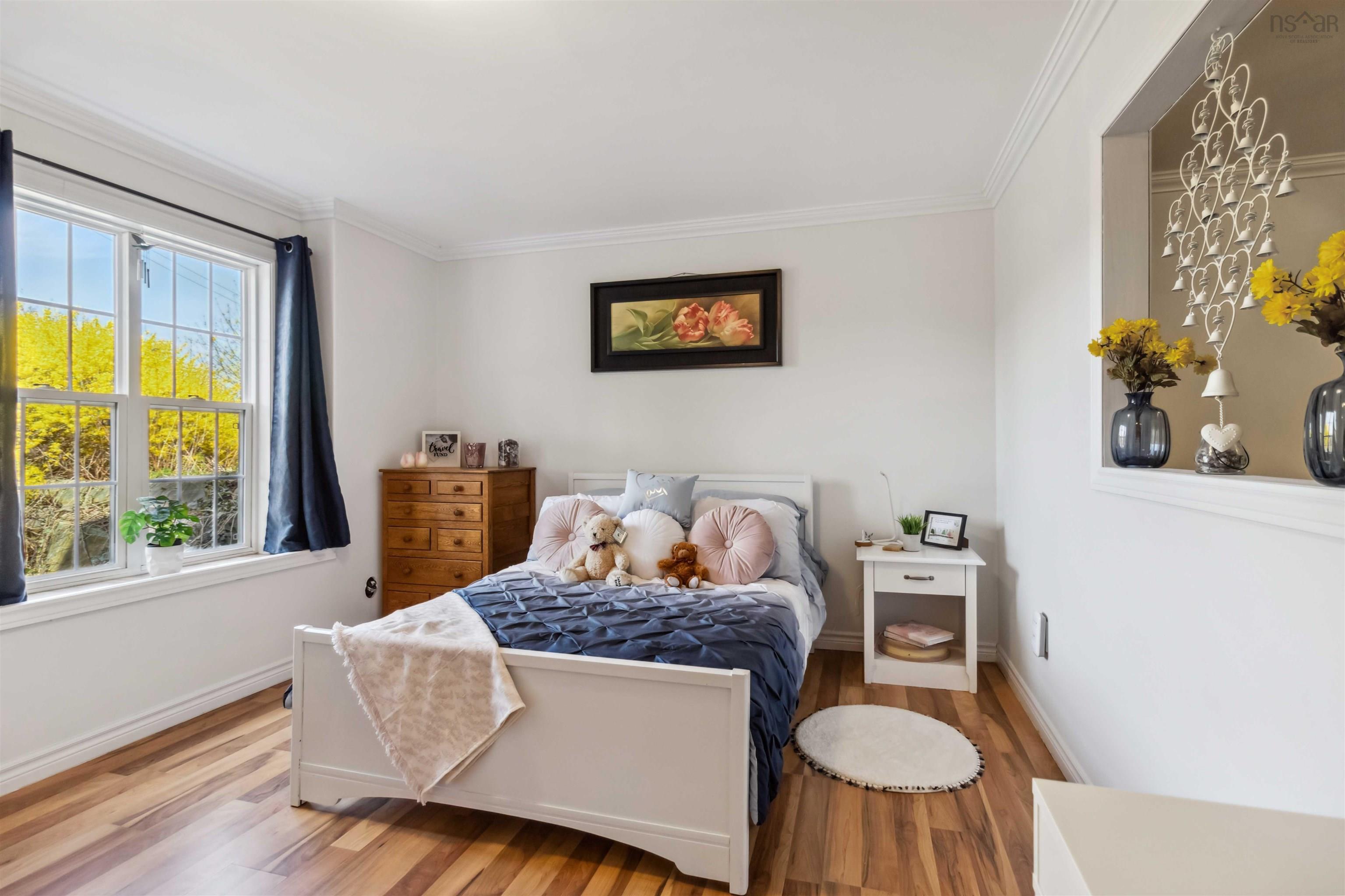 Bedroom featuring wood finished floors, crown molding, and baseboards