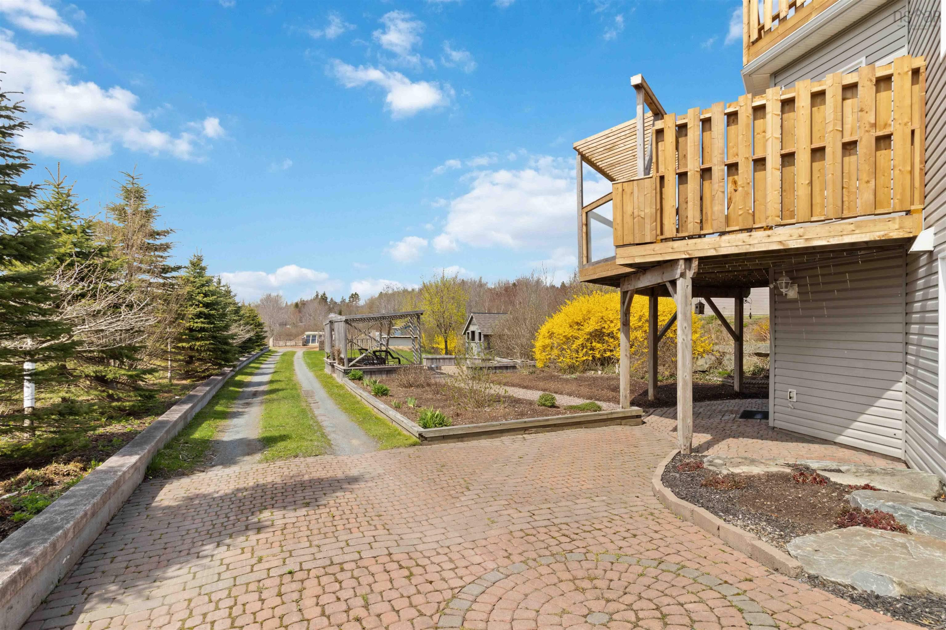 View of yard with a wooden deck and a patio