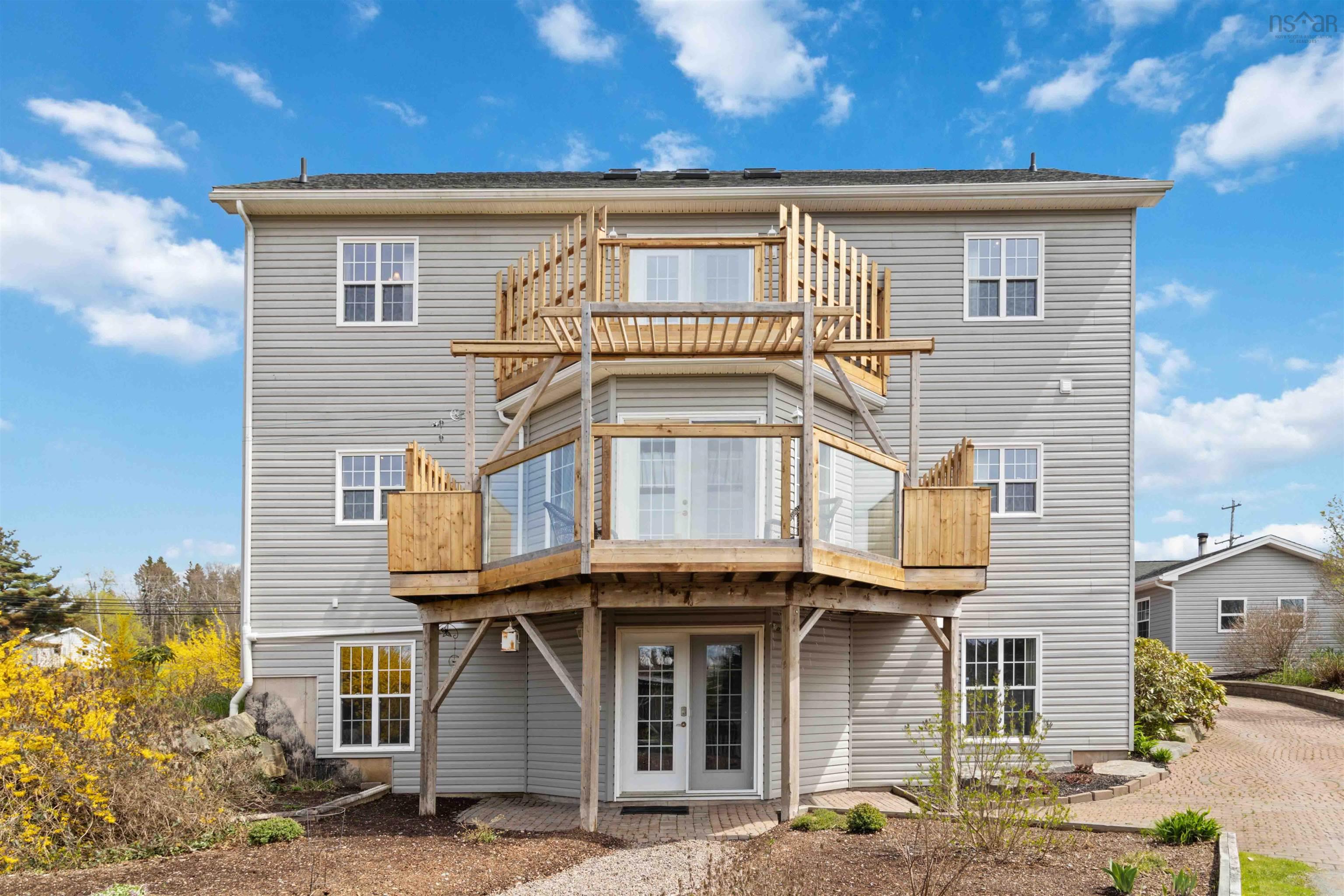 Back of property featuring french doors, a deck, and a balcony