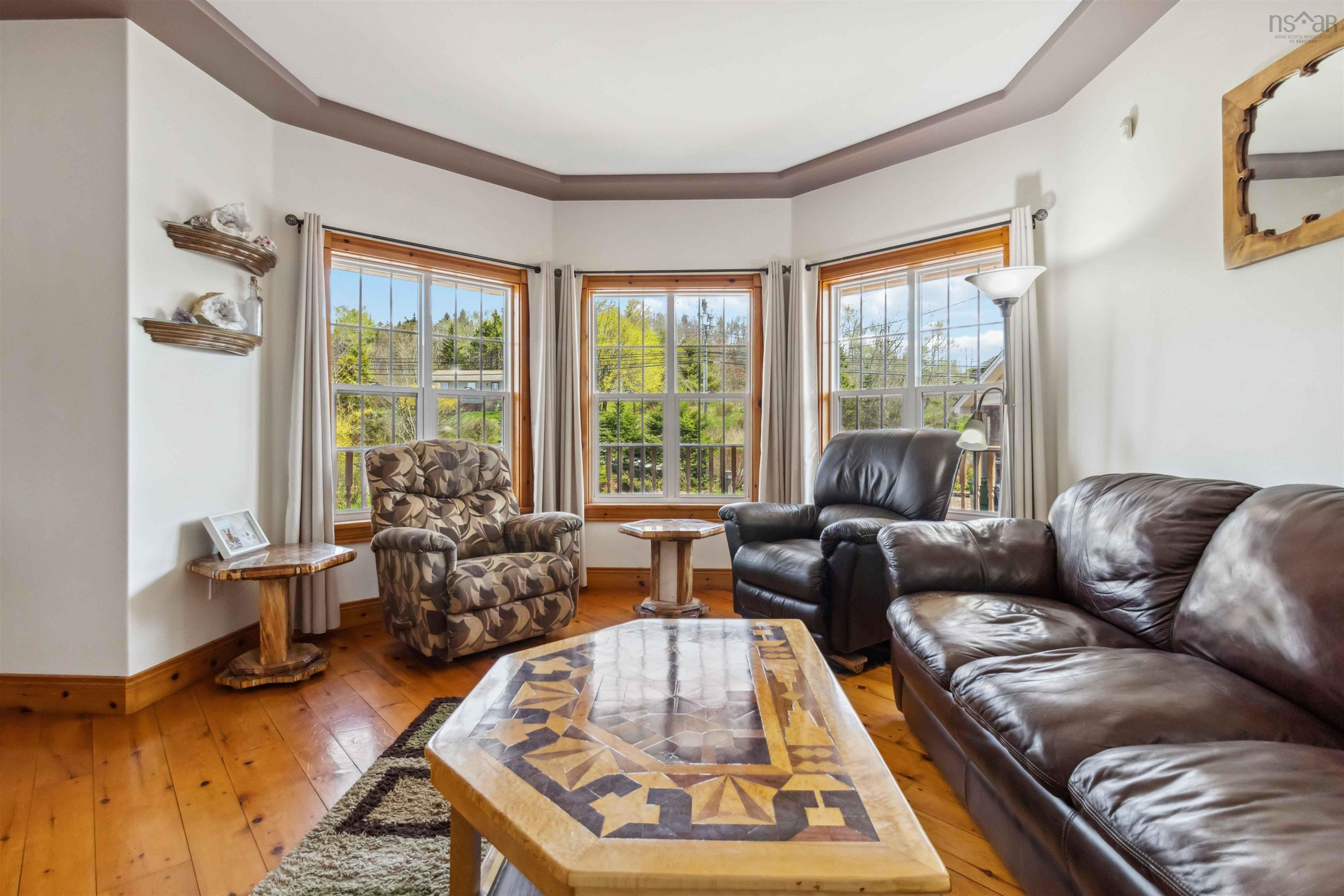 Living area with light wood-type flooring, plenty of natural light, and baseboards