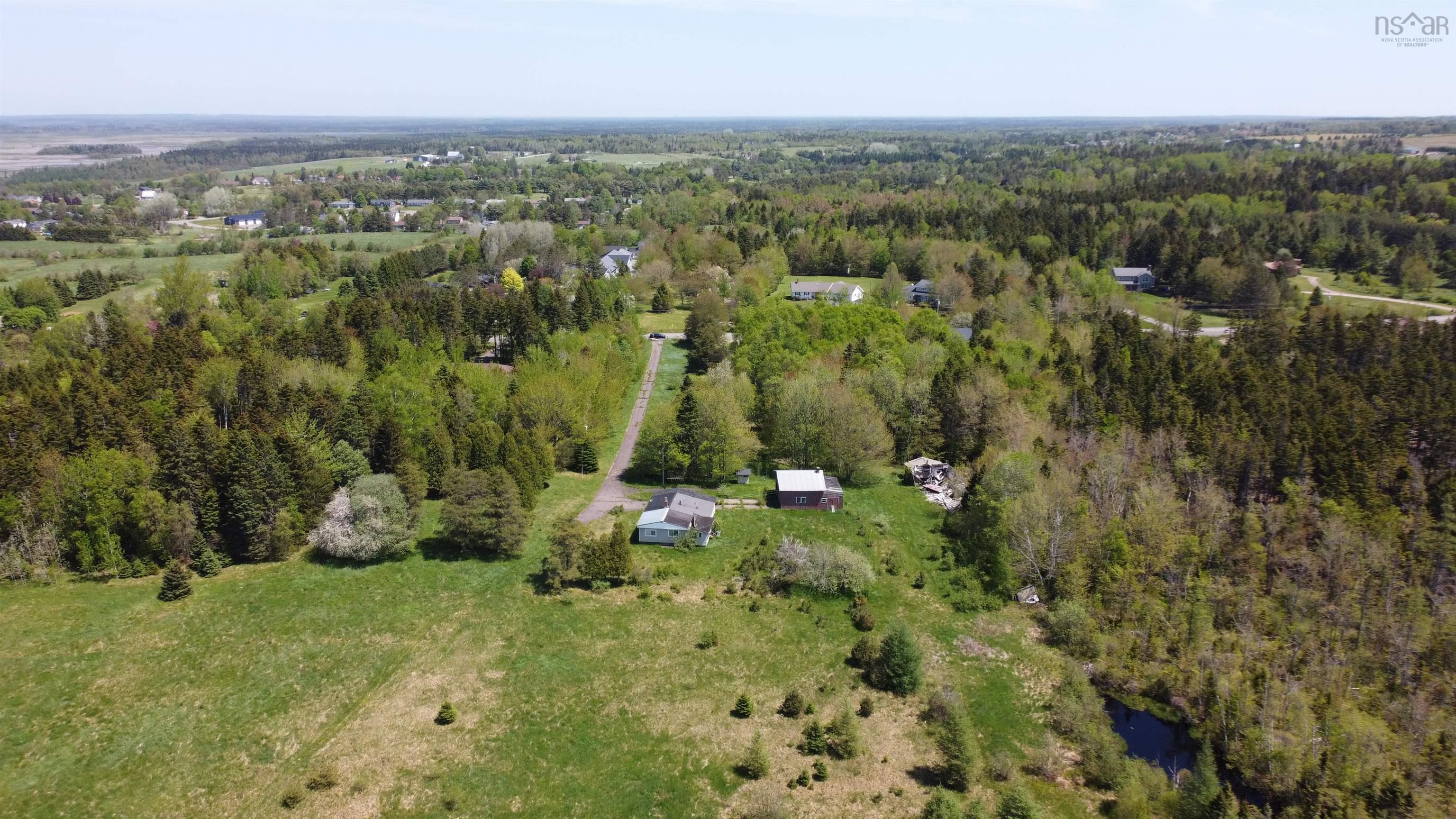 Aerial view of property and surrounding area with a forest