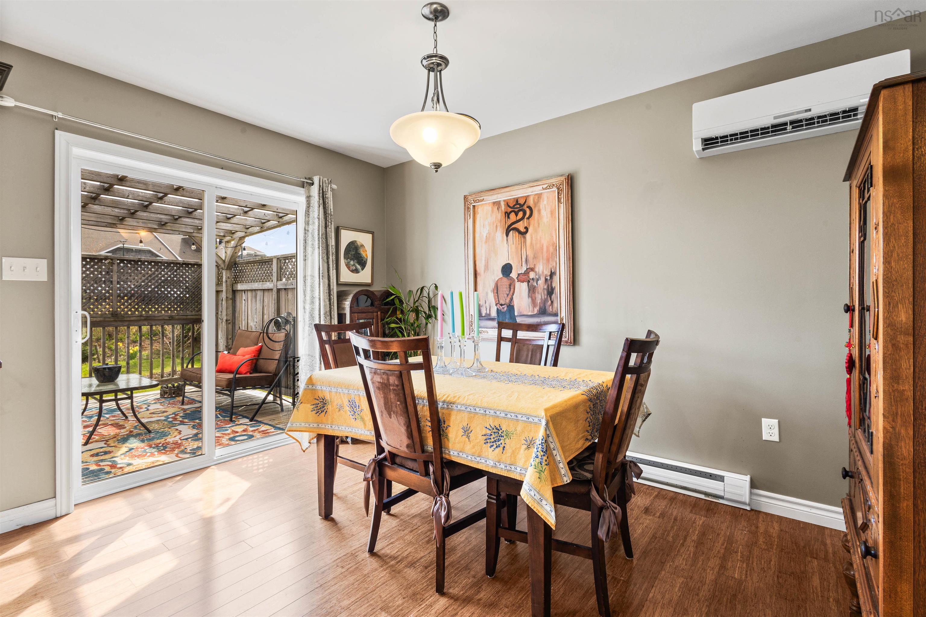 Dining space with baseboard heating, an AC wall unit, light wood-style flooring, and baseboards