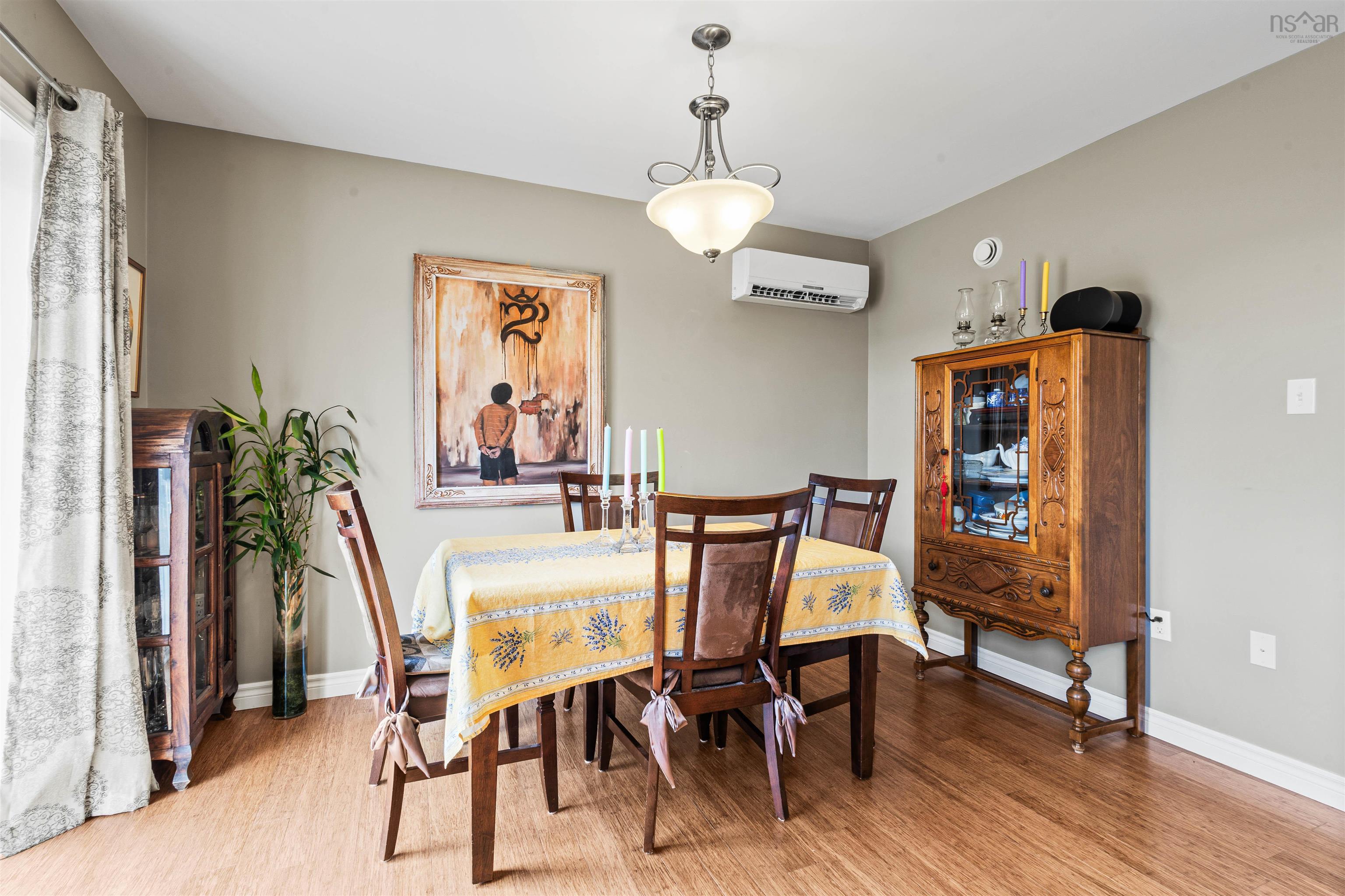 Dining area featuring an AC wall unit, wood finished floors, and baseboards