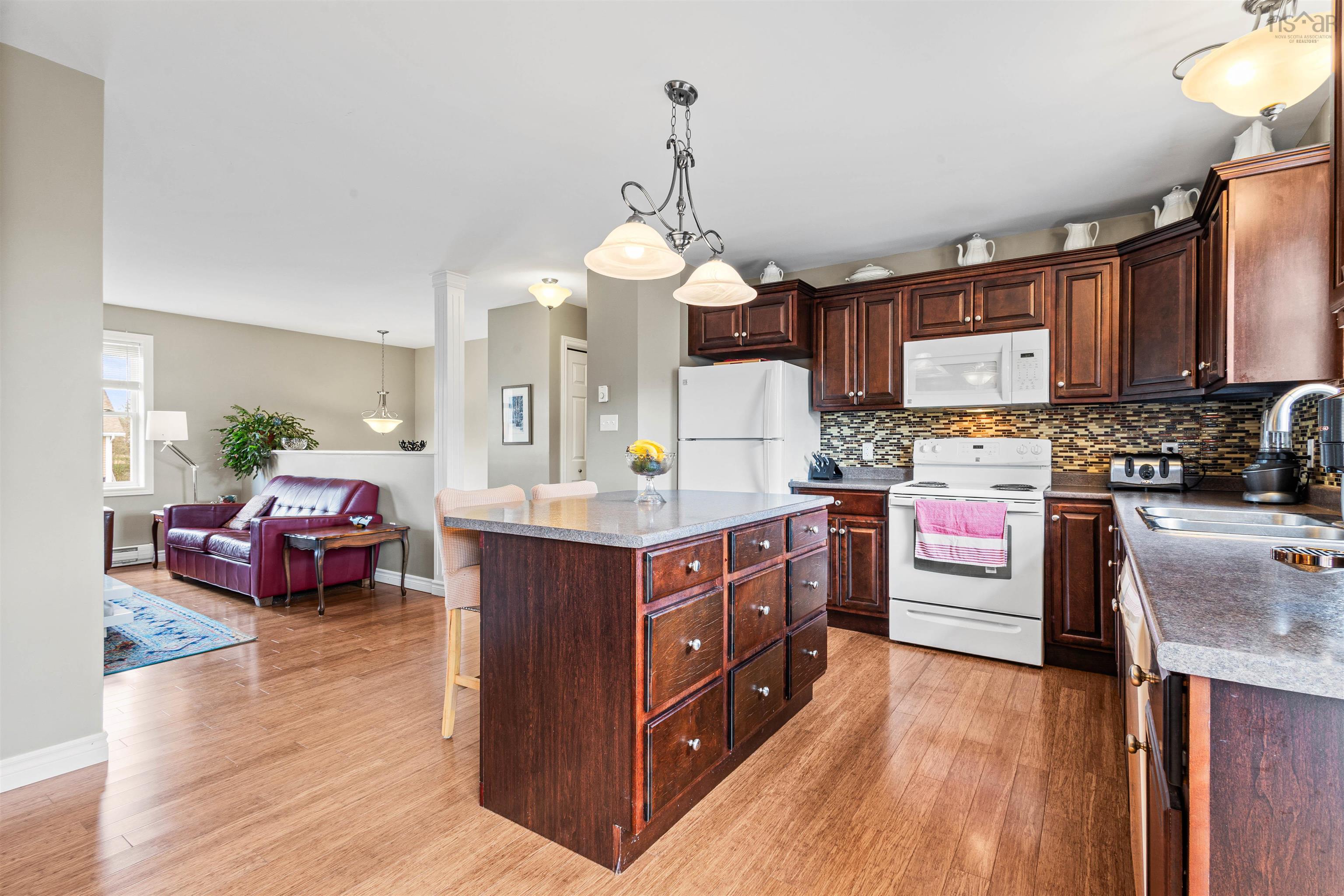 Kitchen featuring white appliances, a sink, backsplash, and light wood finished floors