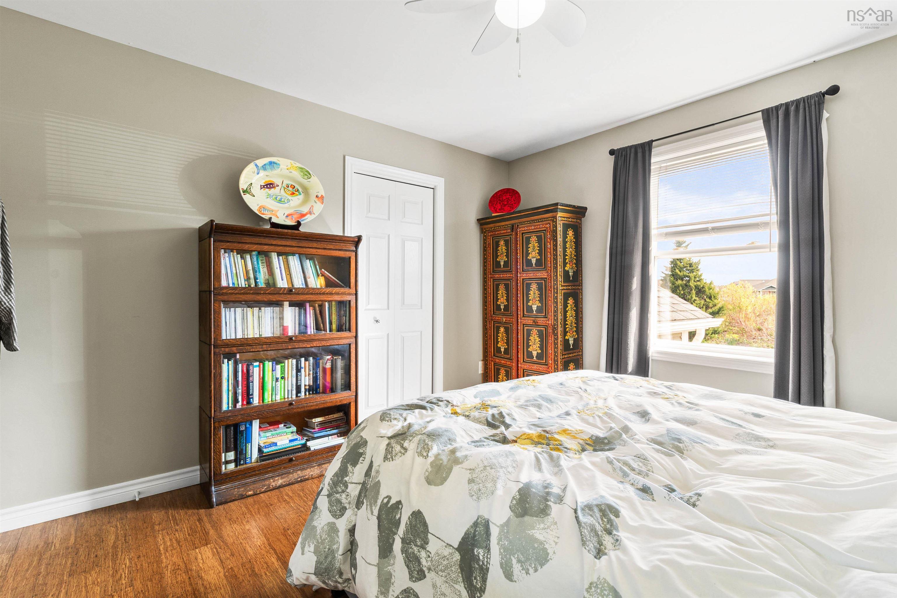Bedroom featuring wood finished floors, baseboards, and a ceiling fan