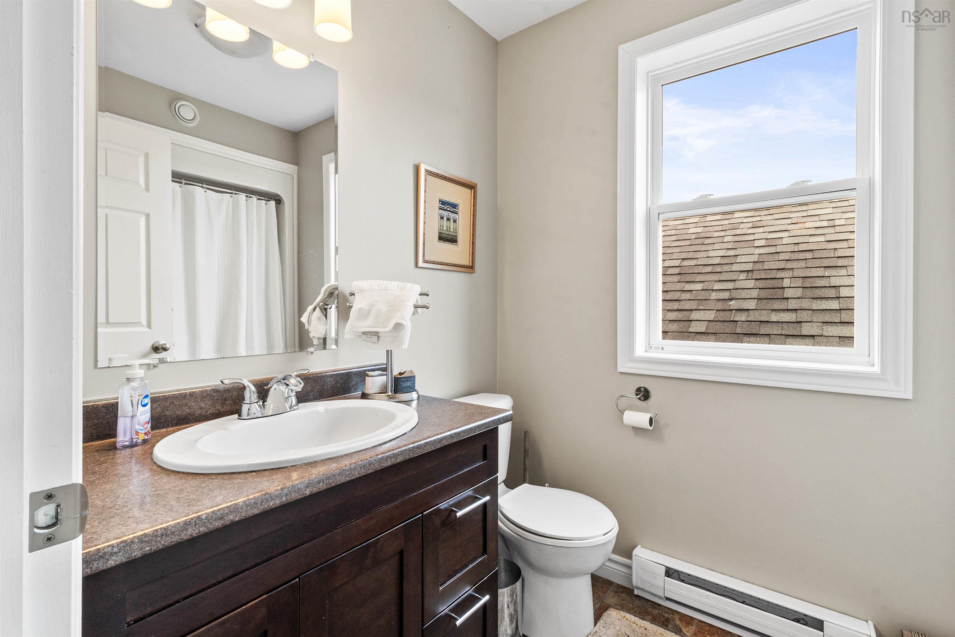 Bathroom with a baseboard radiator, vanity, and toilet