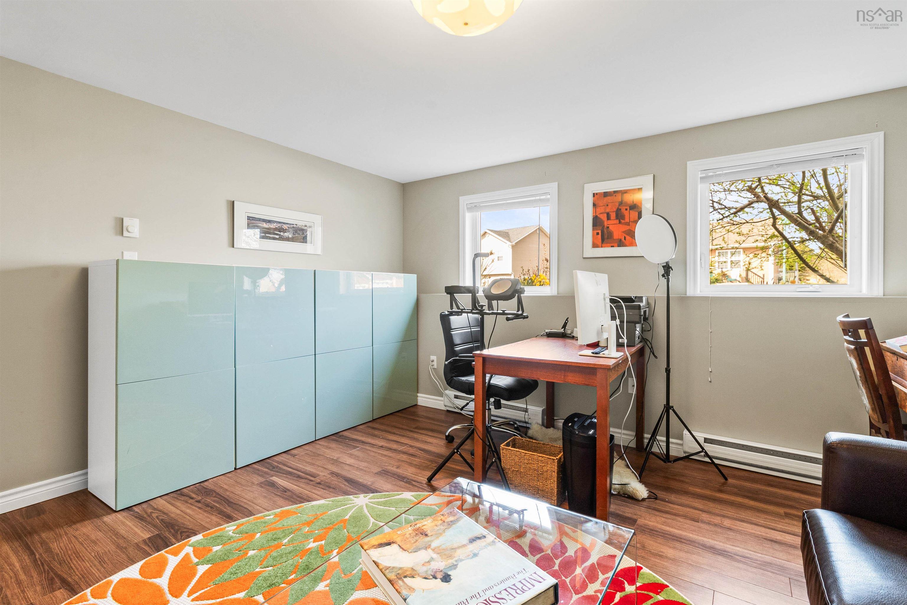 Office area with a baseboard radiator, plenty of natural light, wood finished floors, and baseboards