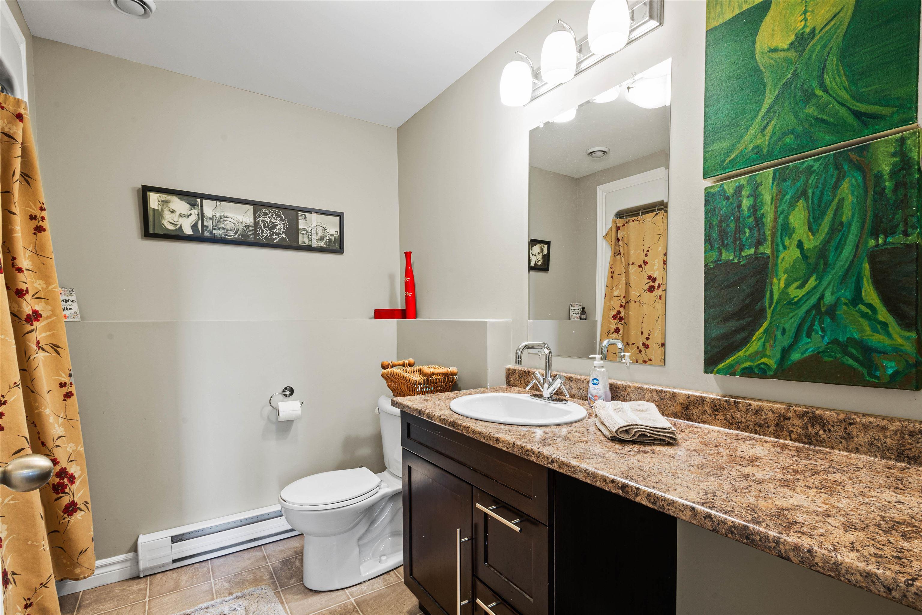 Full bathroom featuring a baseboard radiator, vanity, toilet, and baseboards