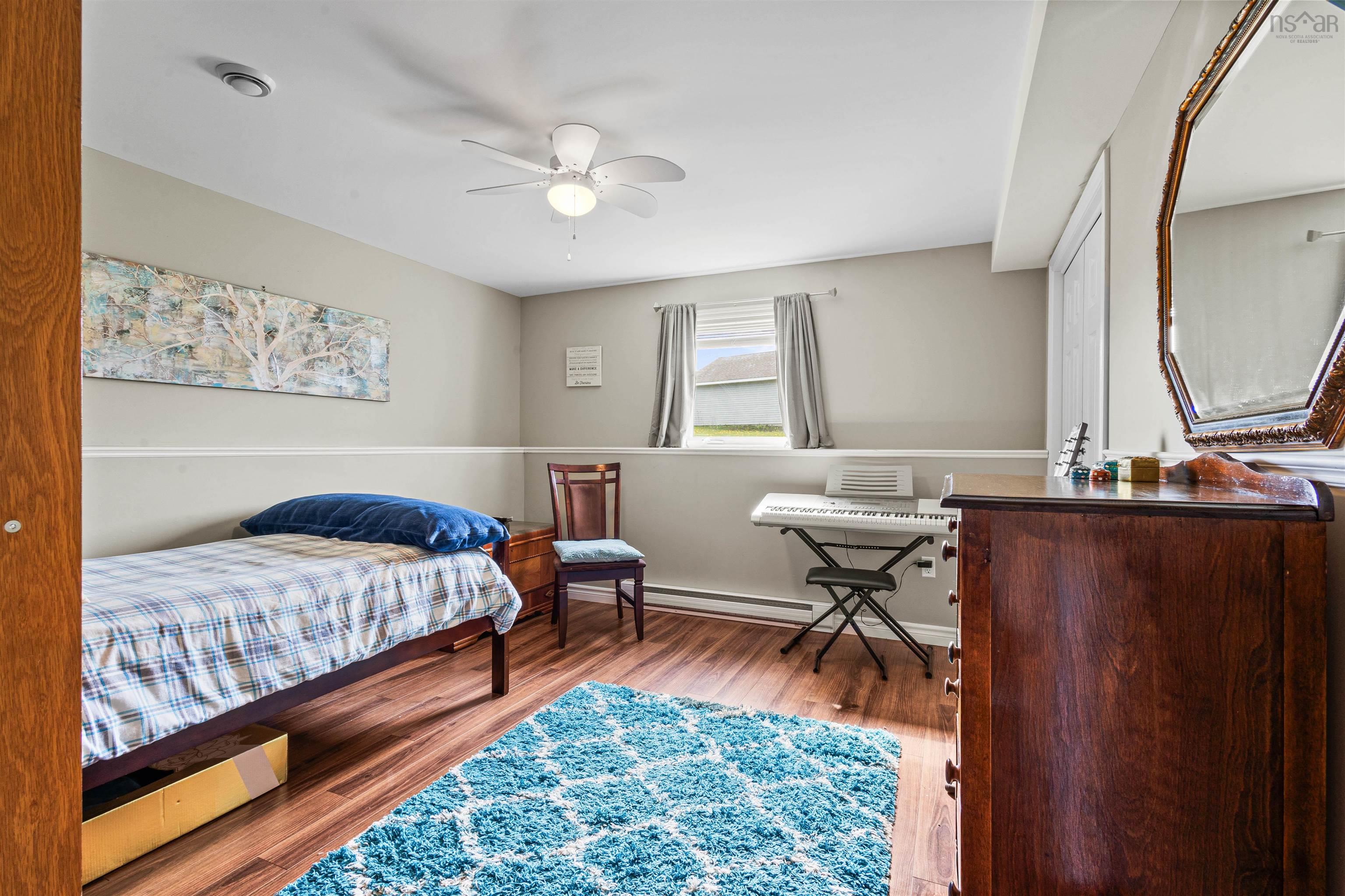 Bedroom featuring wood finished floors and a baseboard radiator