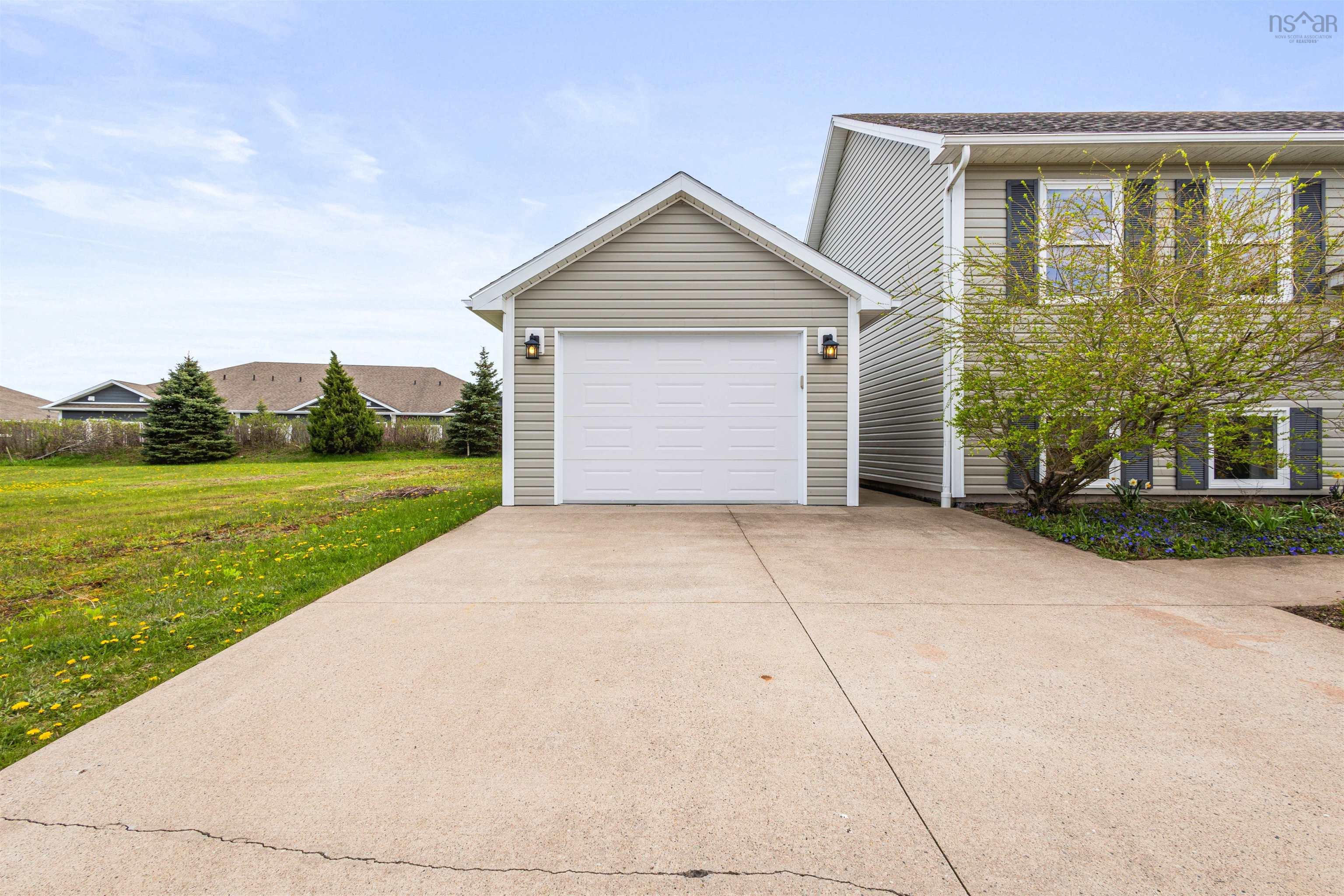 View of front of property with concrete driveway, a garage, and a front lawn