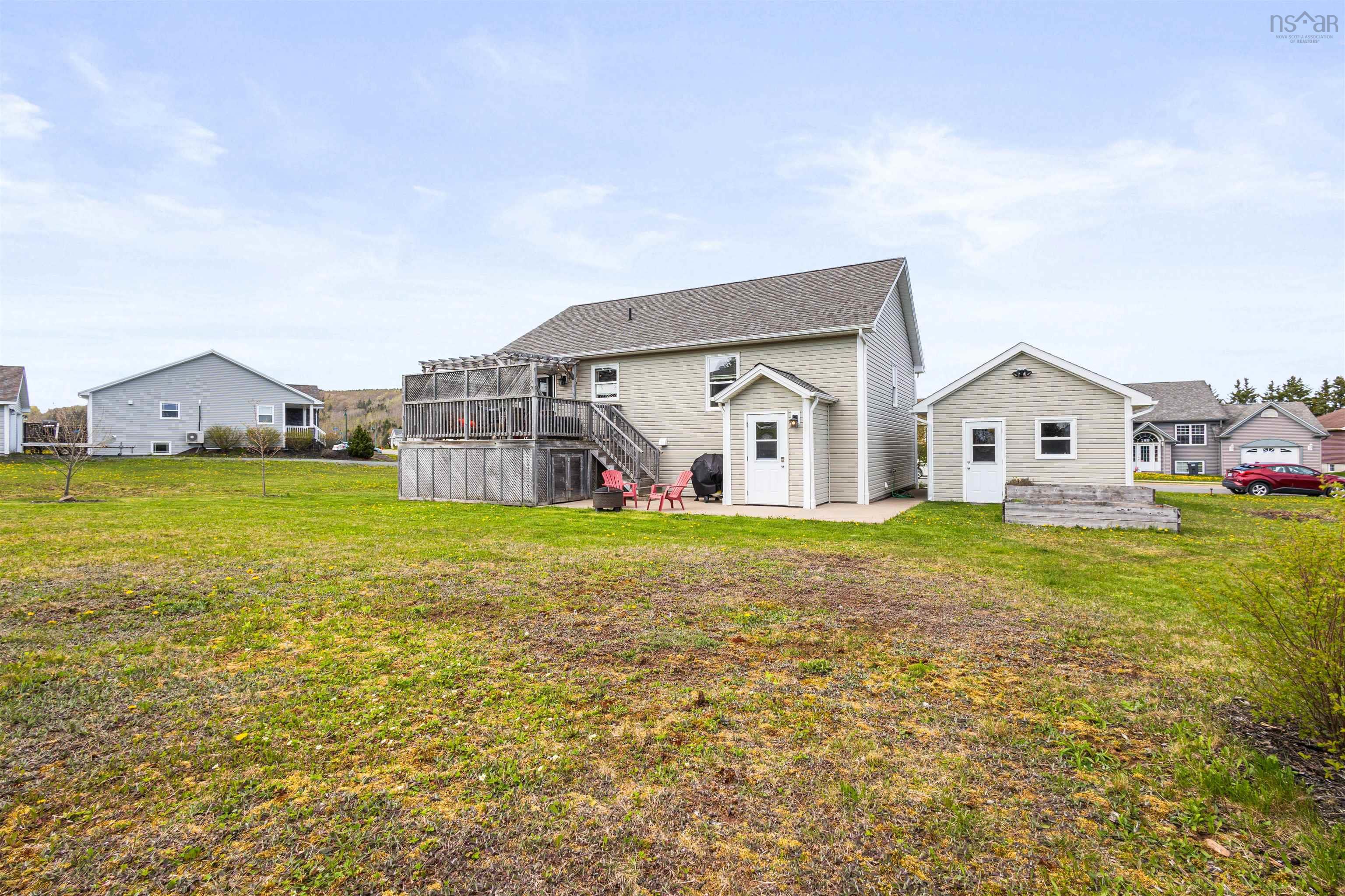 Back of property featuring a patio area, stairs, a yard, and a deck