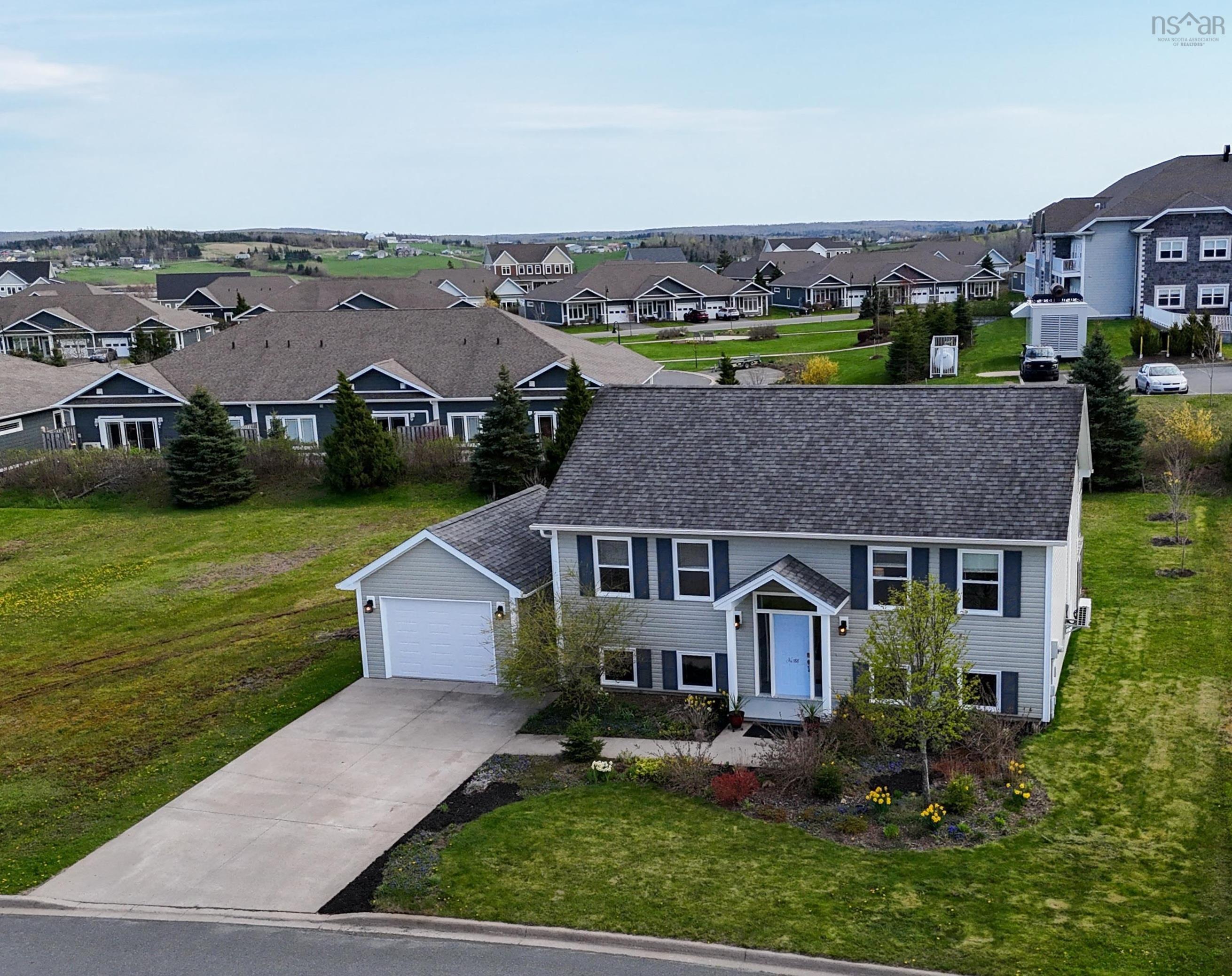 View of front of house with a residential view, driveway, a front lawn, and a garage
