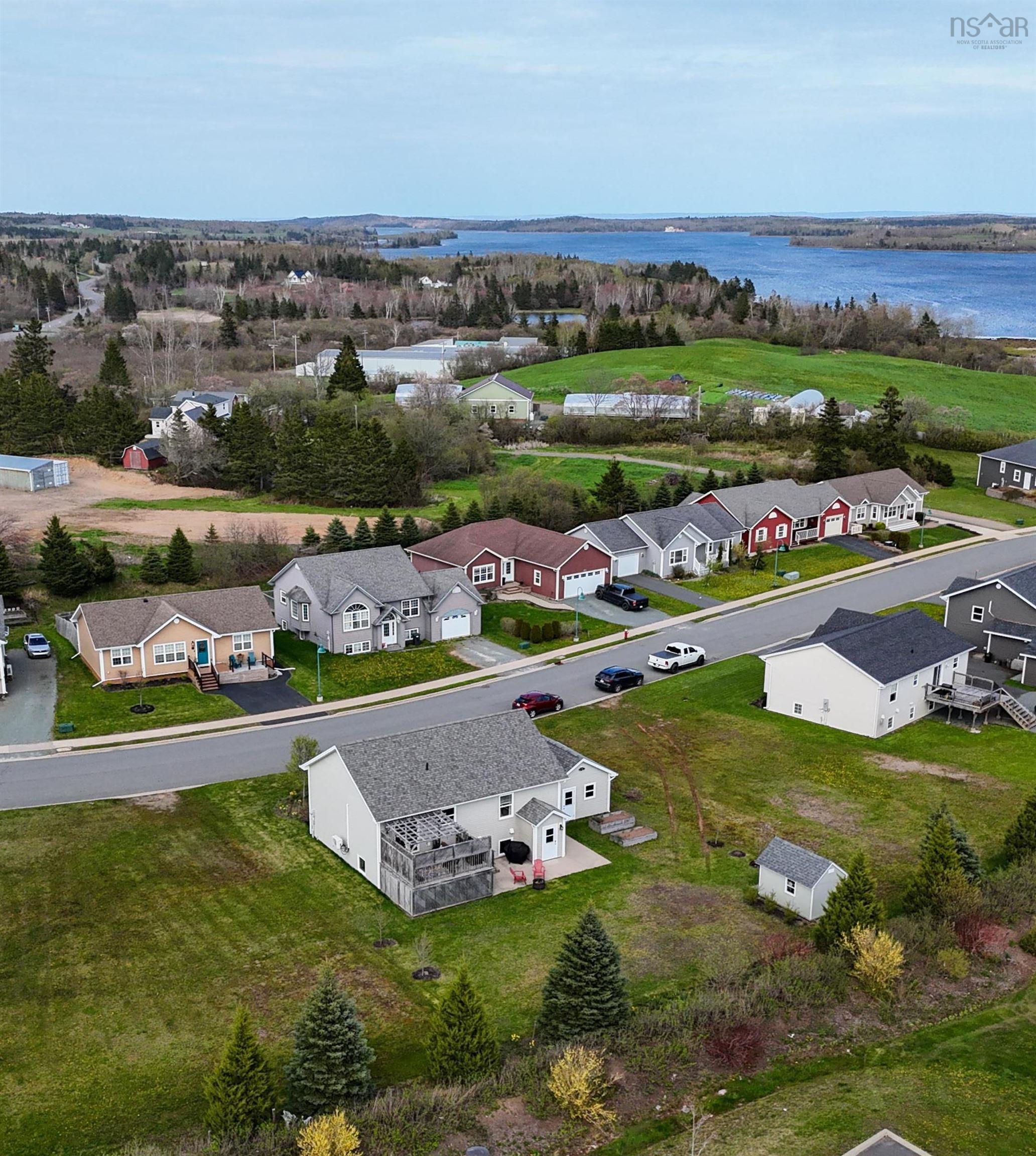 Aerial perspective of suburban area featuring a nearby body of water