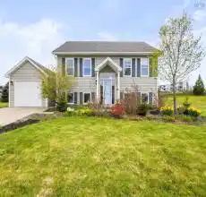 Bi-level home with a front lawn and concrete driveway