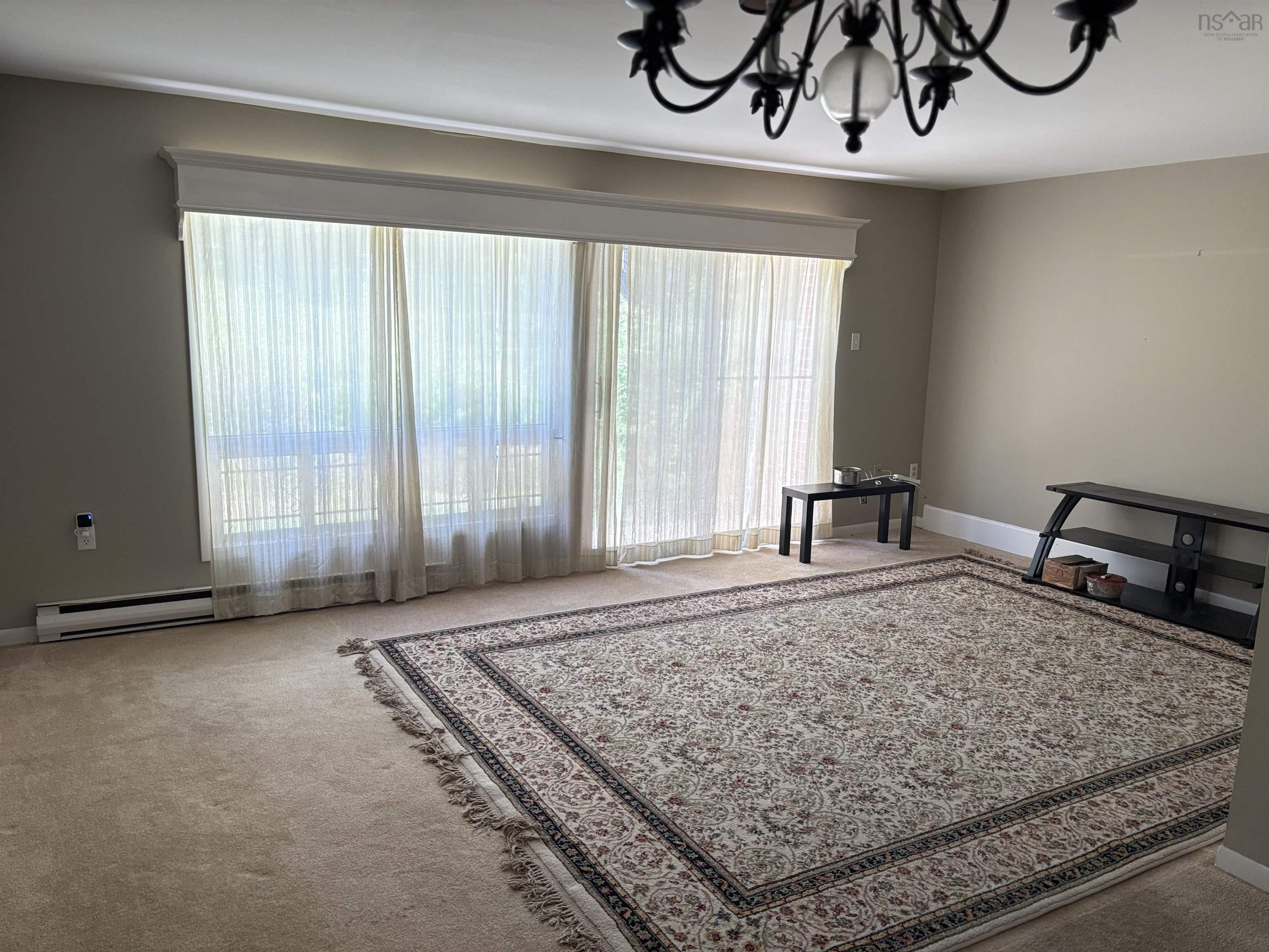 Living area featuring a chandelier, healthy amount of natural light, and carpet