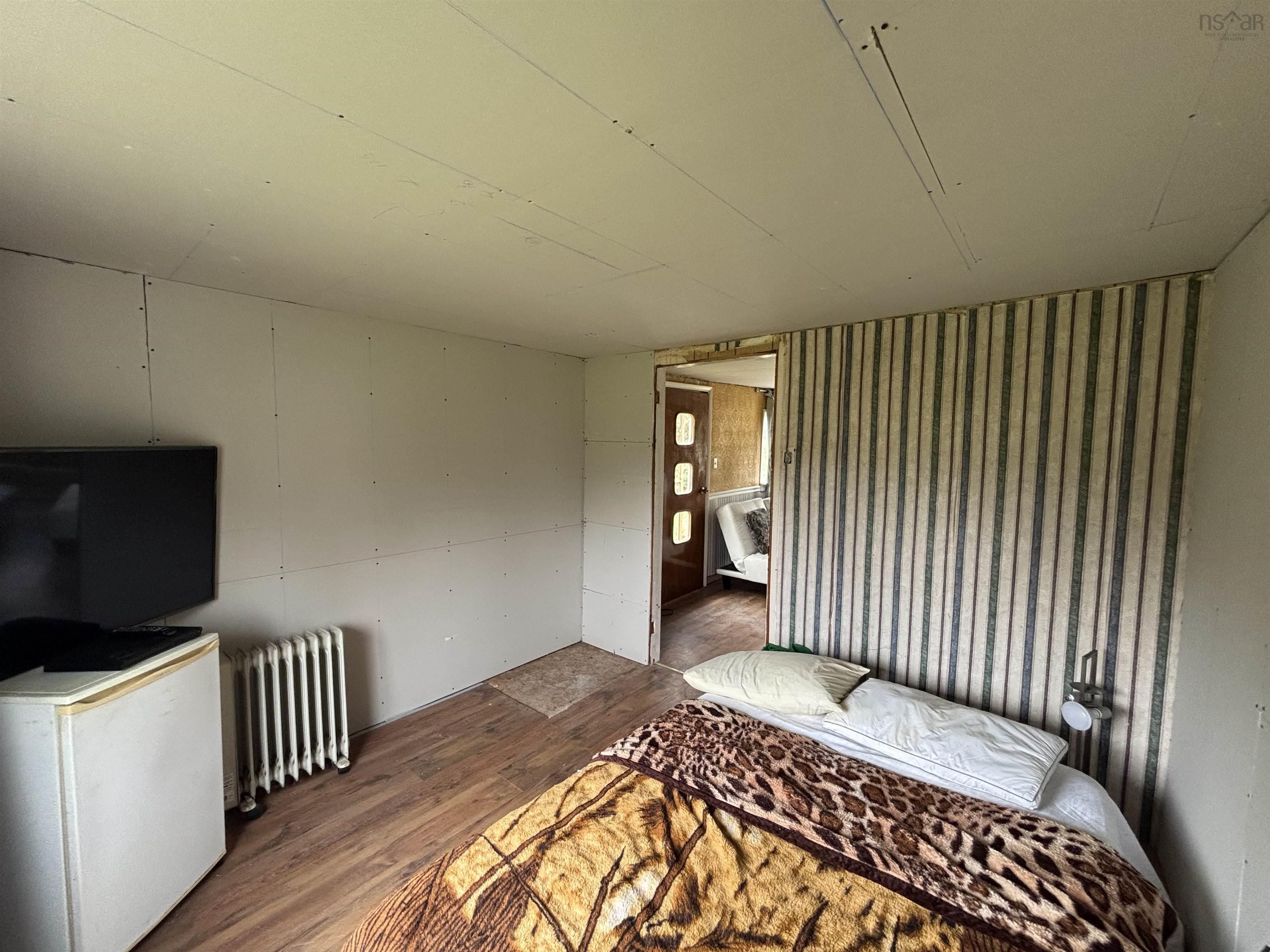 Bedroom with wood finished floors and radiator