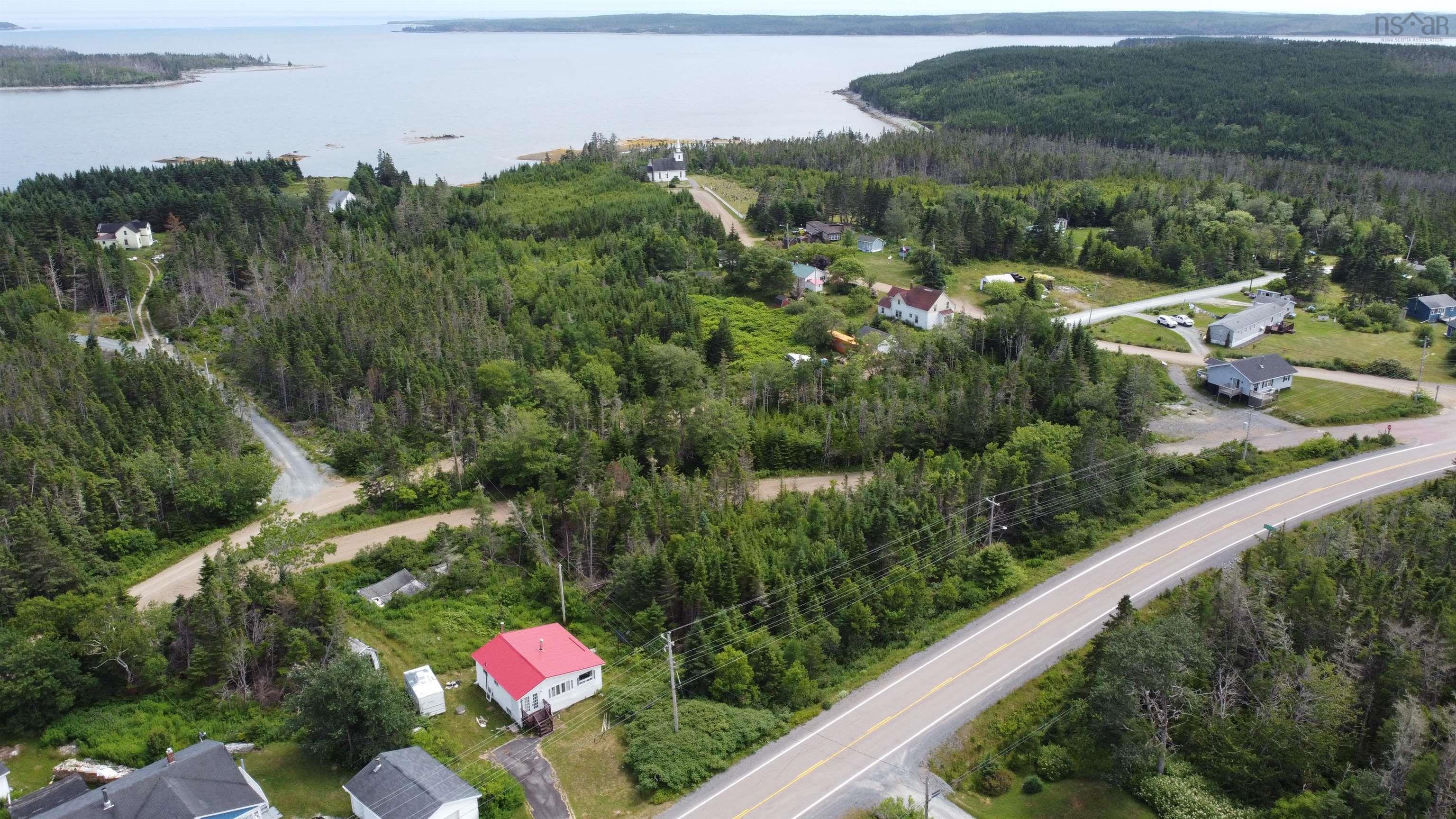 Aerial overview of property's location with a heavily wooded area and a large body of water