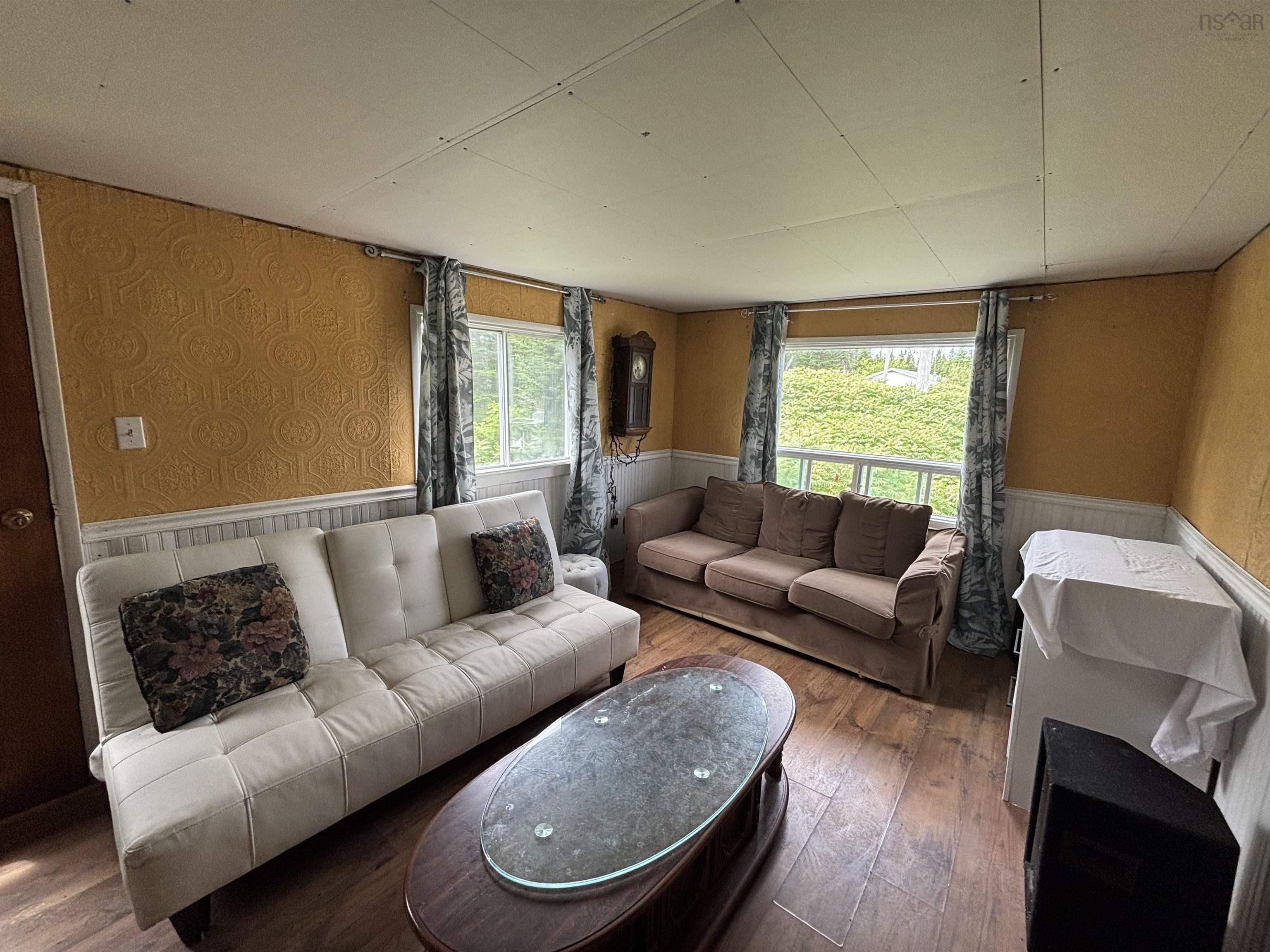 Living area featuring wainscoting, hardwood / wood-style floors, and wallpapered walls