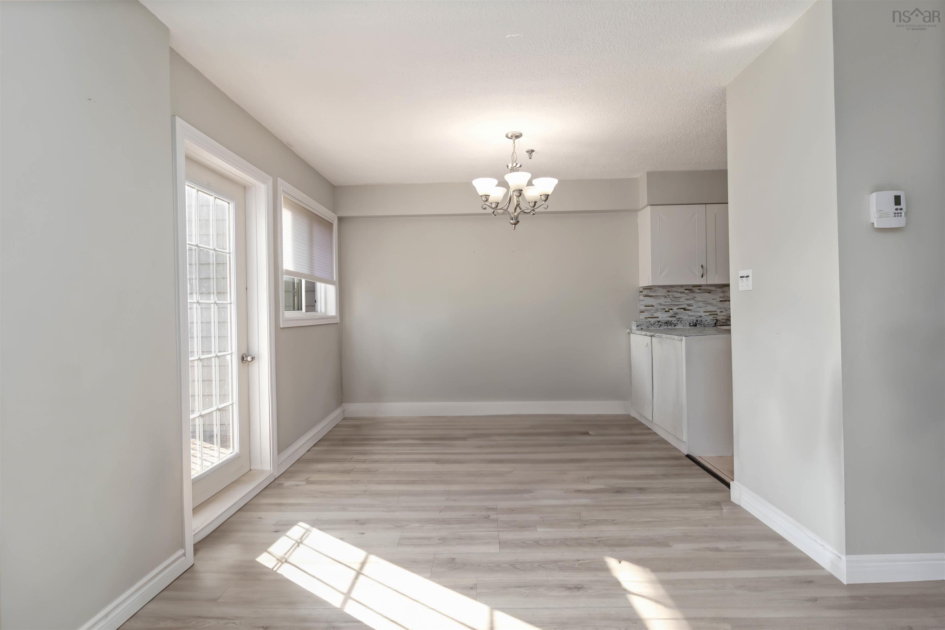 Unfurnished dining area with a chandelier and light wood-type flooring