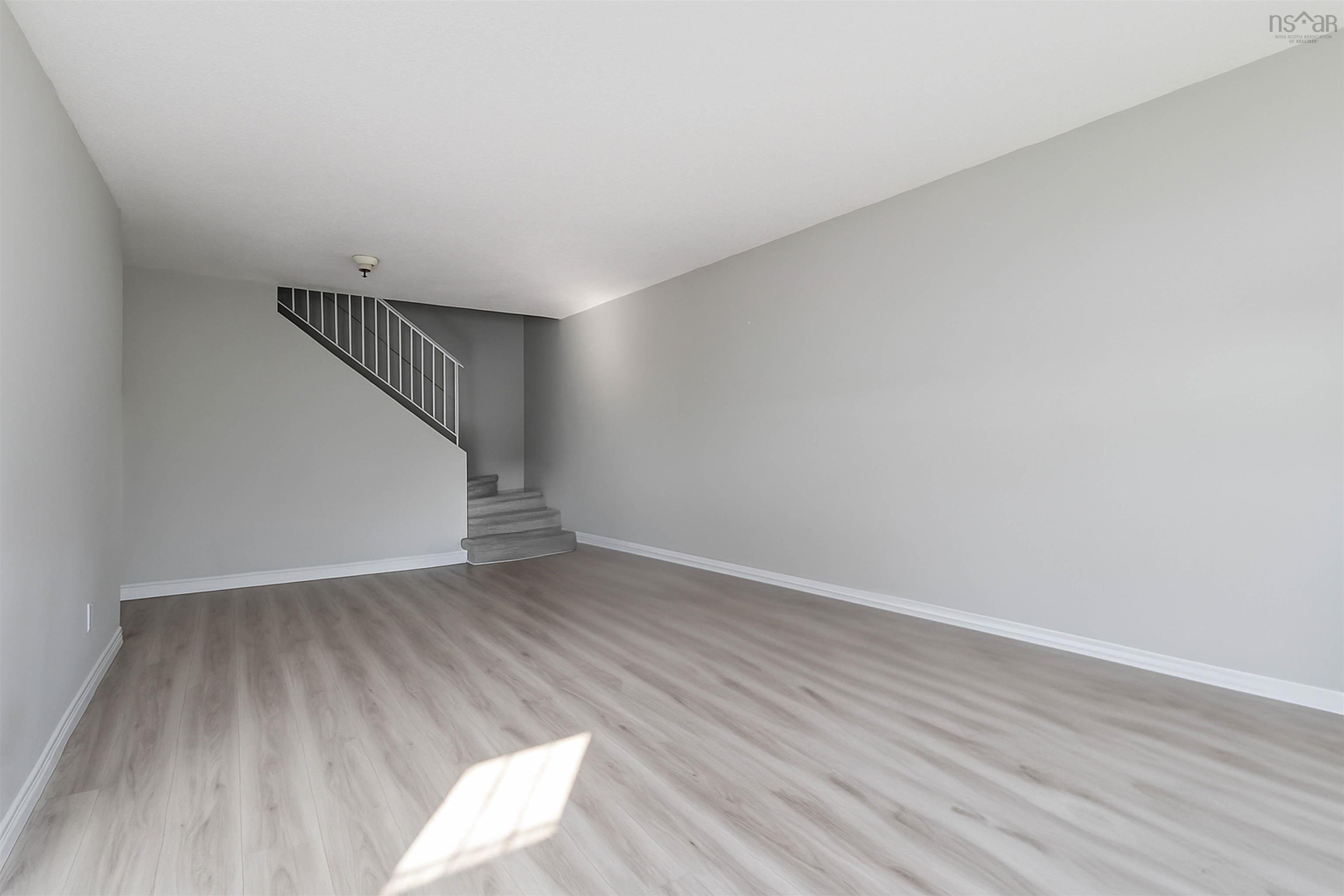 Unfurnished living room with wood finished floors and stairs
