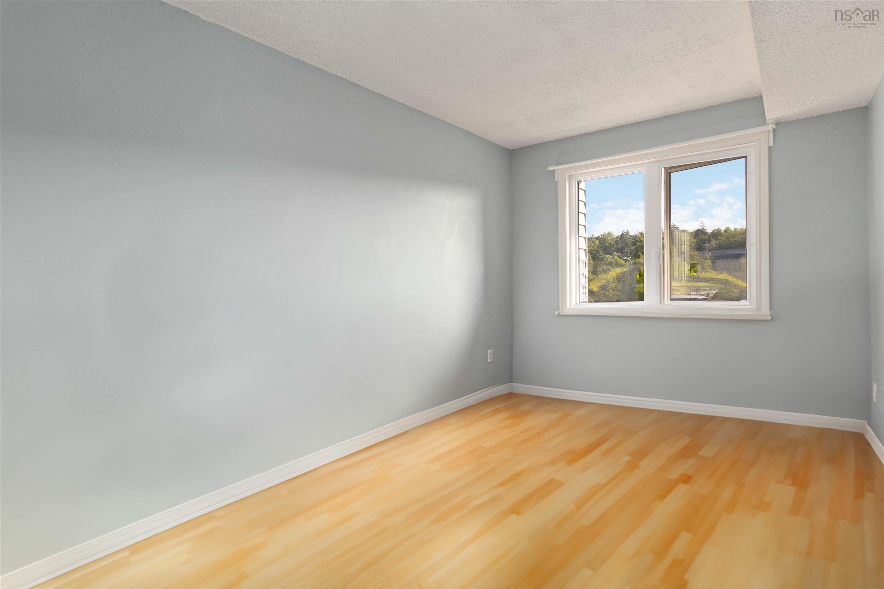 Empty room featuring wood finished floors and a textured ceiling