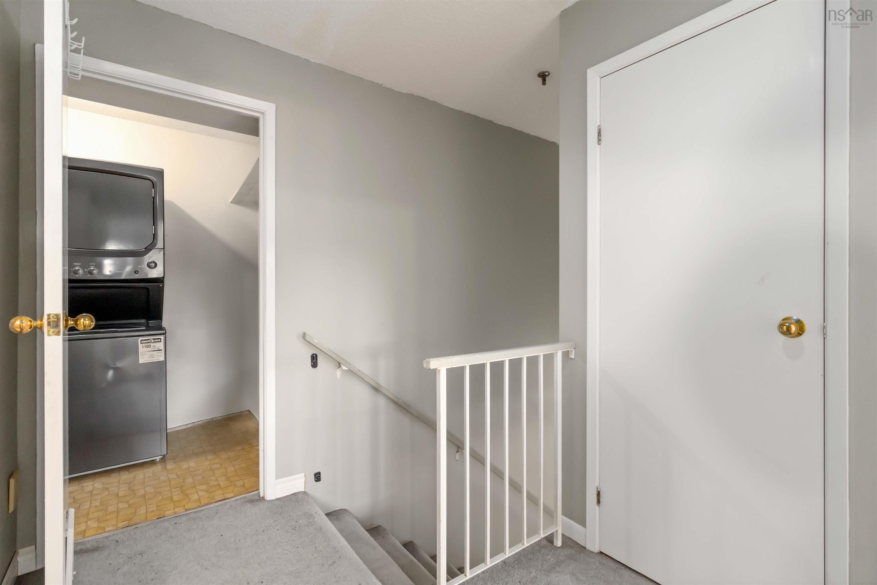 Staircase featuring estacked washer and dryer and carpet floors