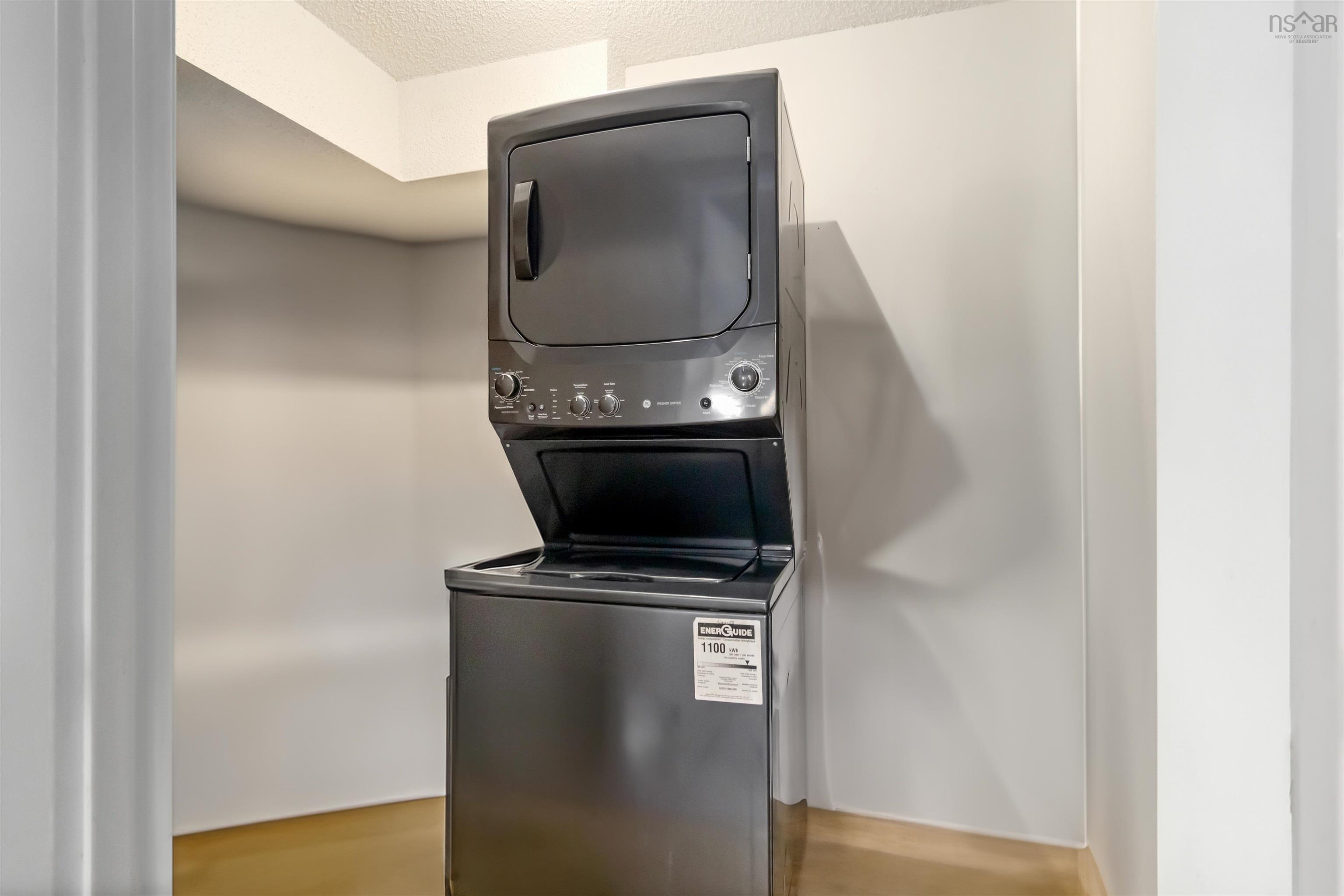 Laundry area featuring stacked washing machine and dryer and a textured ceiling