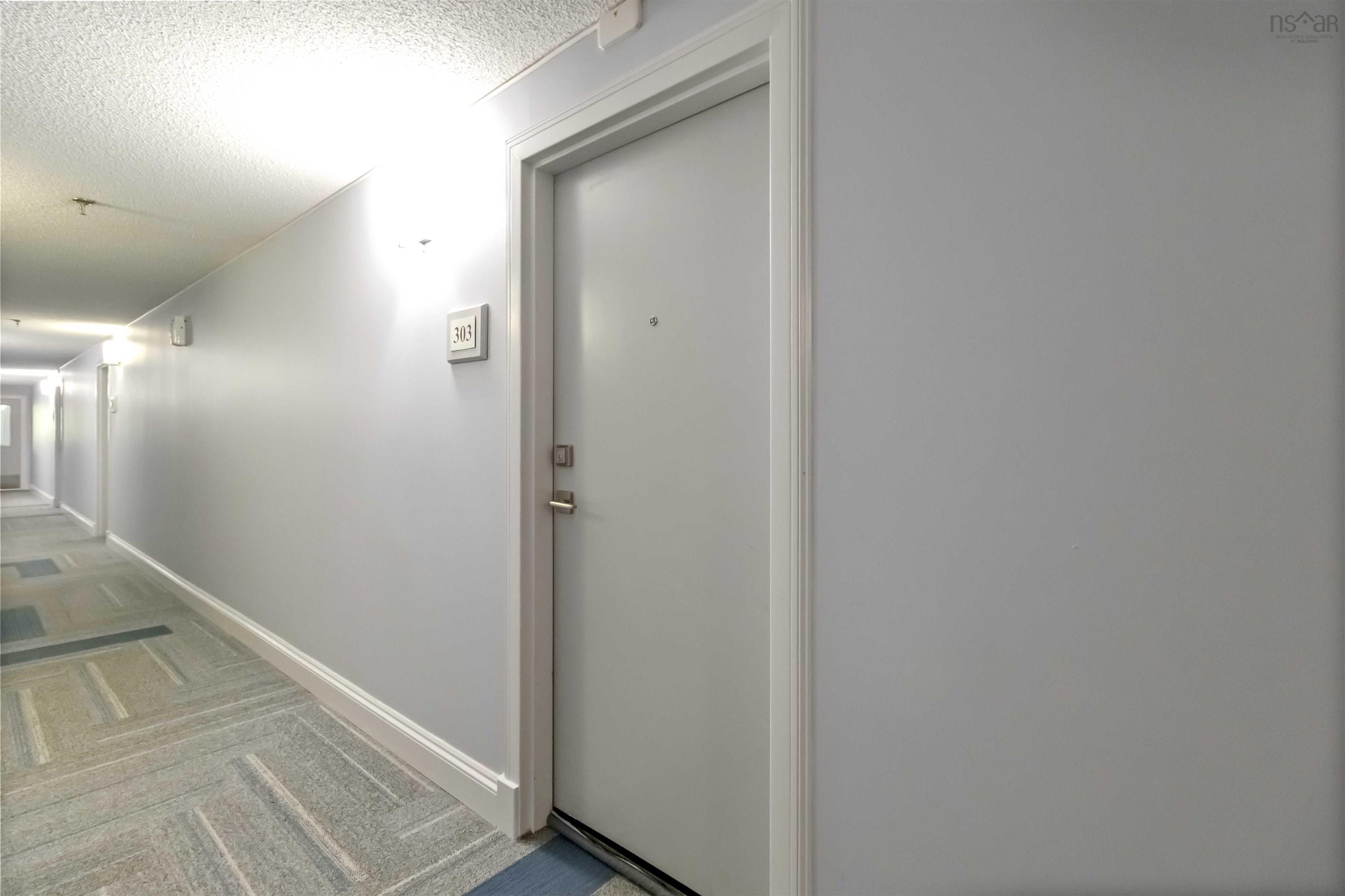 Hall featuring a textured ceiling and carpet flooring
