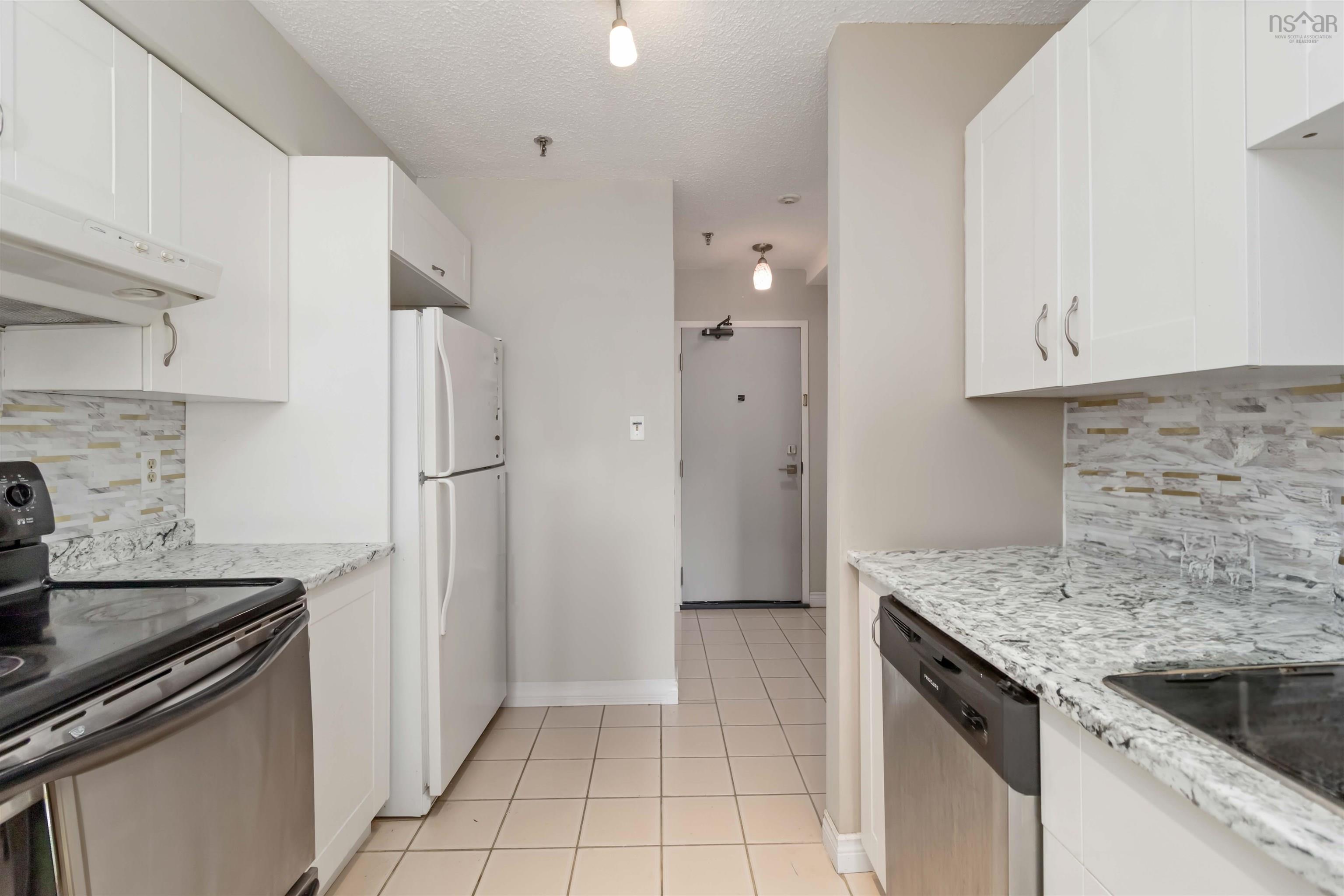 Kitchen featuring decorative backsplash, electric stove, freestanding refrigerator, stainless steel dishwasher, and a textured ceiling