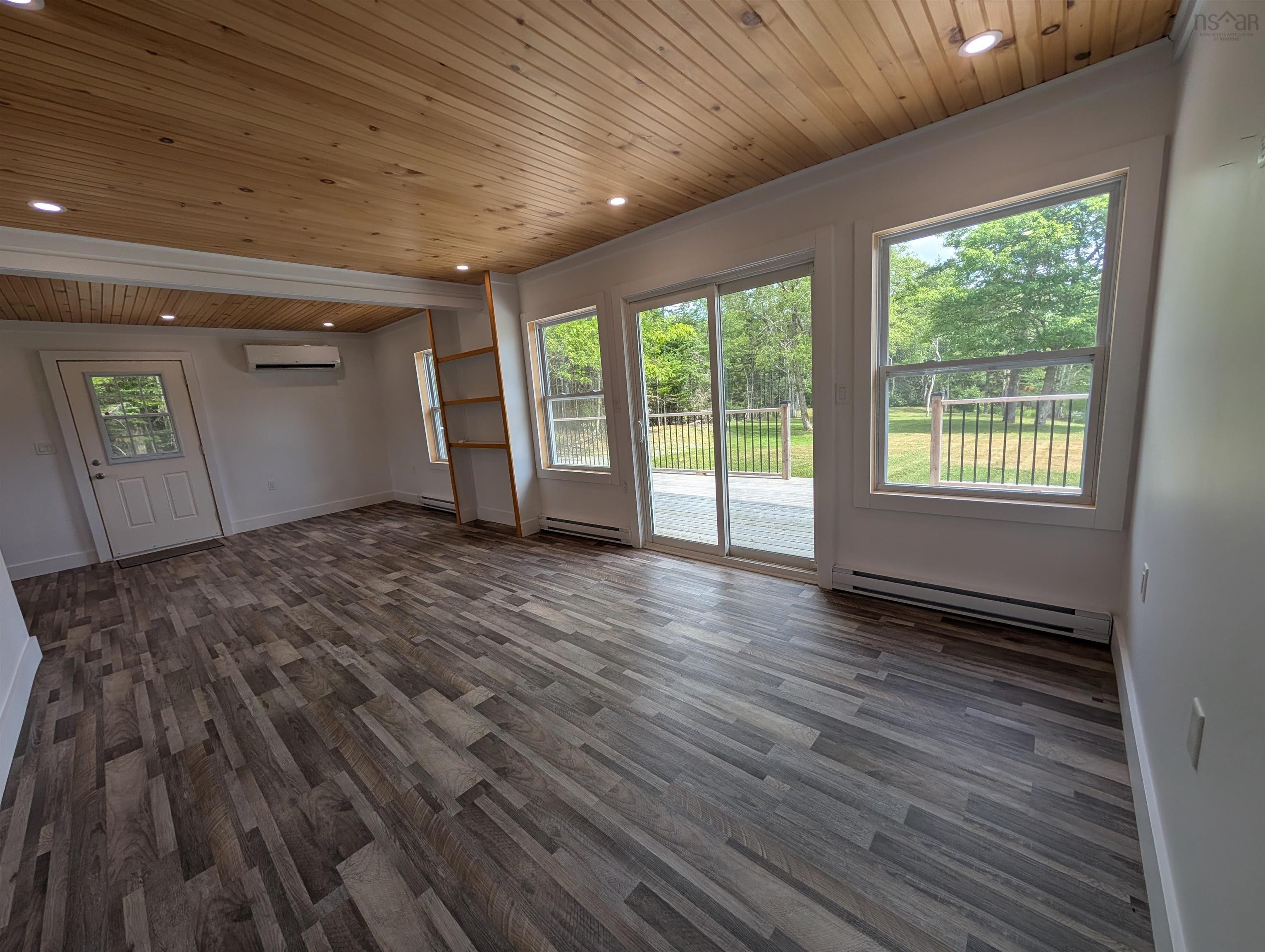 Unfurnished living room featuring wooden ceiling, a baseboard heating unit, dark wood-style floors, and recessed lighting