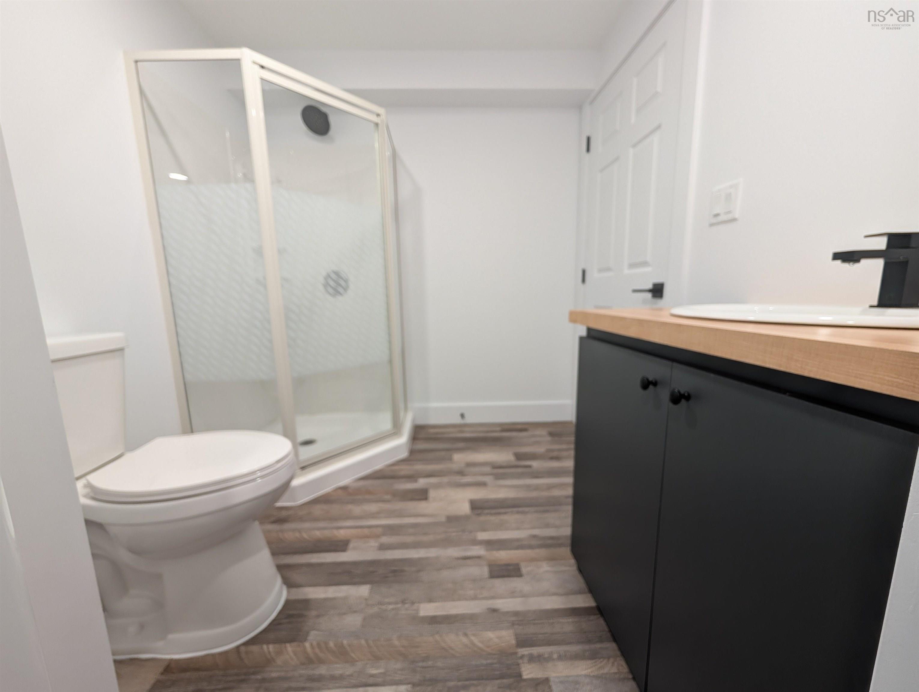 Full bath featuring vanity, a stall shower, and wood finished floors